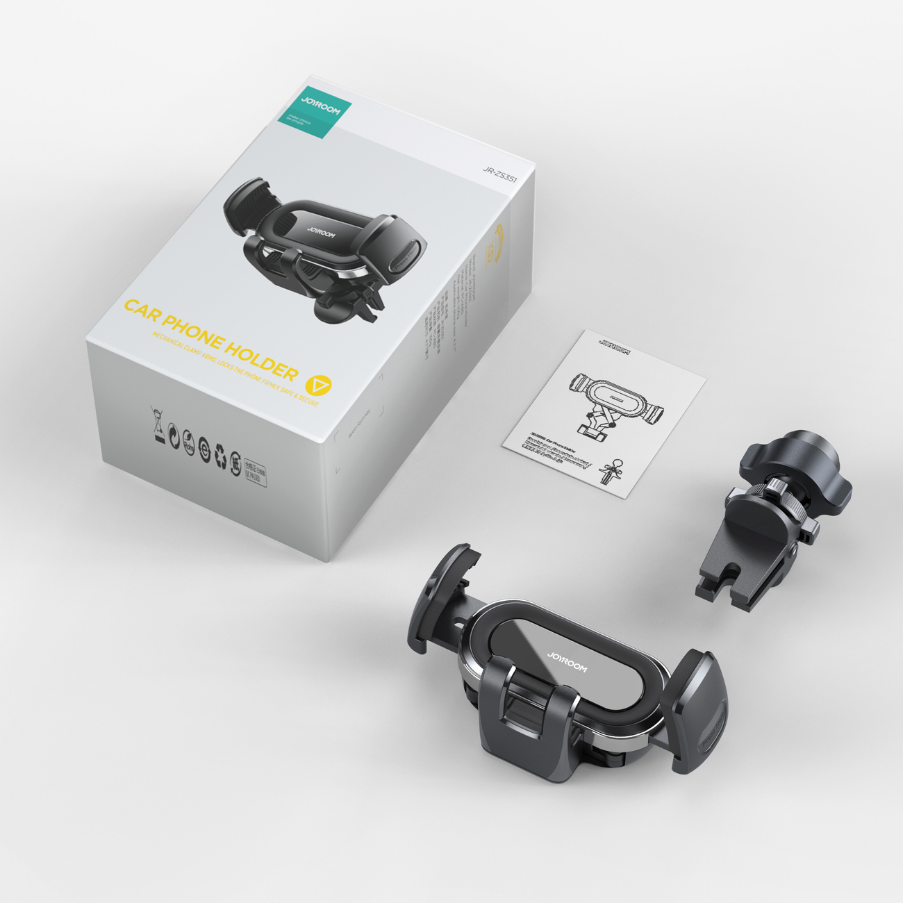 Białe pudełko, uchwyt do telefonu samochodowego i akcesoria. Pudełko ma markę i nazwę modelu.