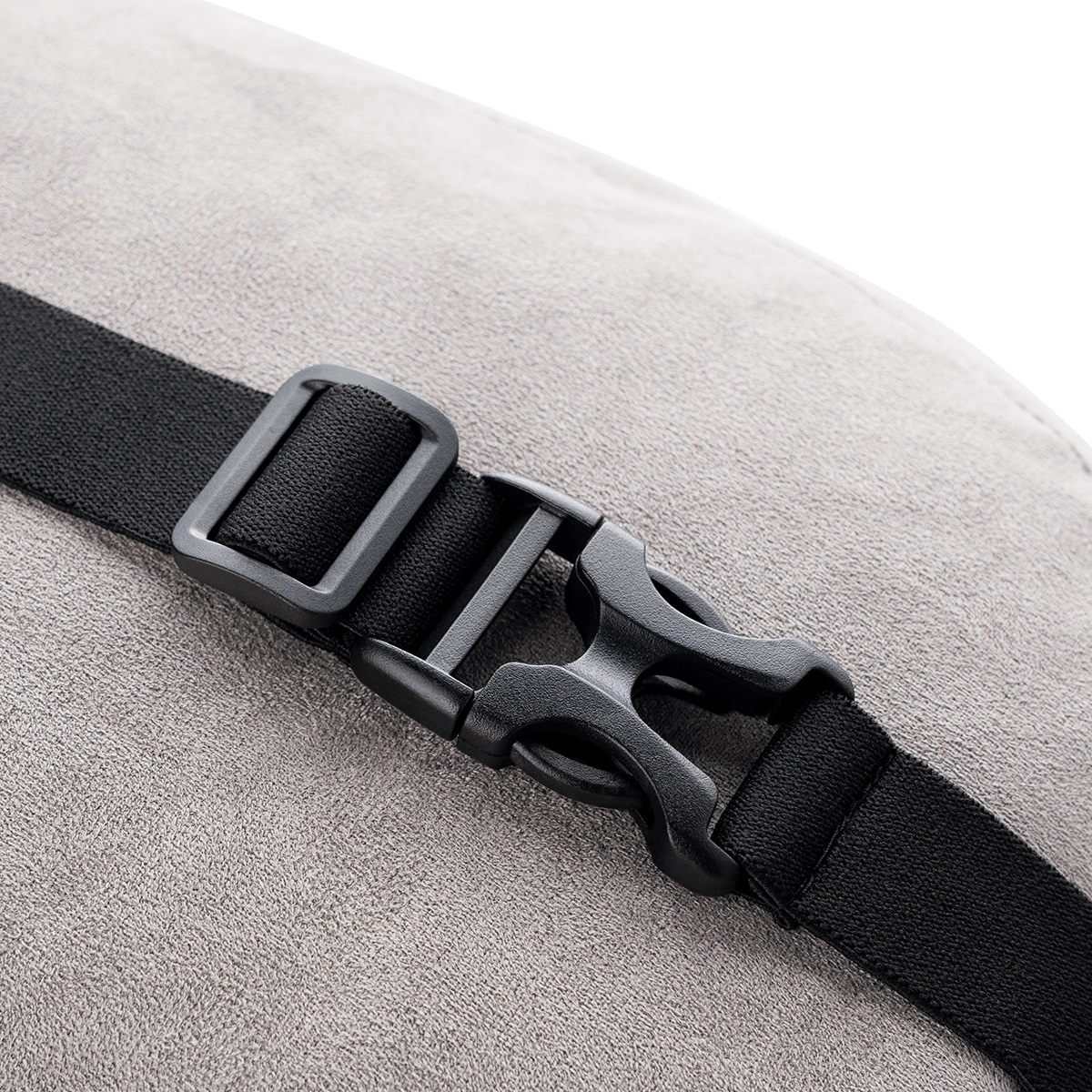 Zbliżenie czarnej plastikowej klamry przymocowanej do szarej powierzchni tkaniny czarnym paskiem.