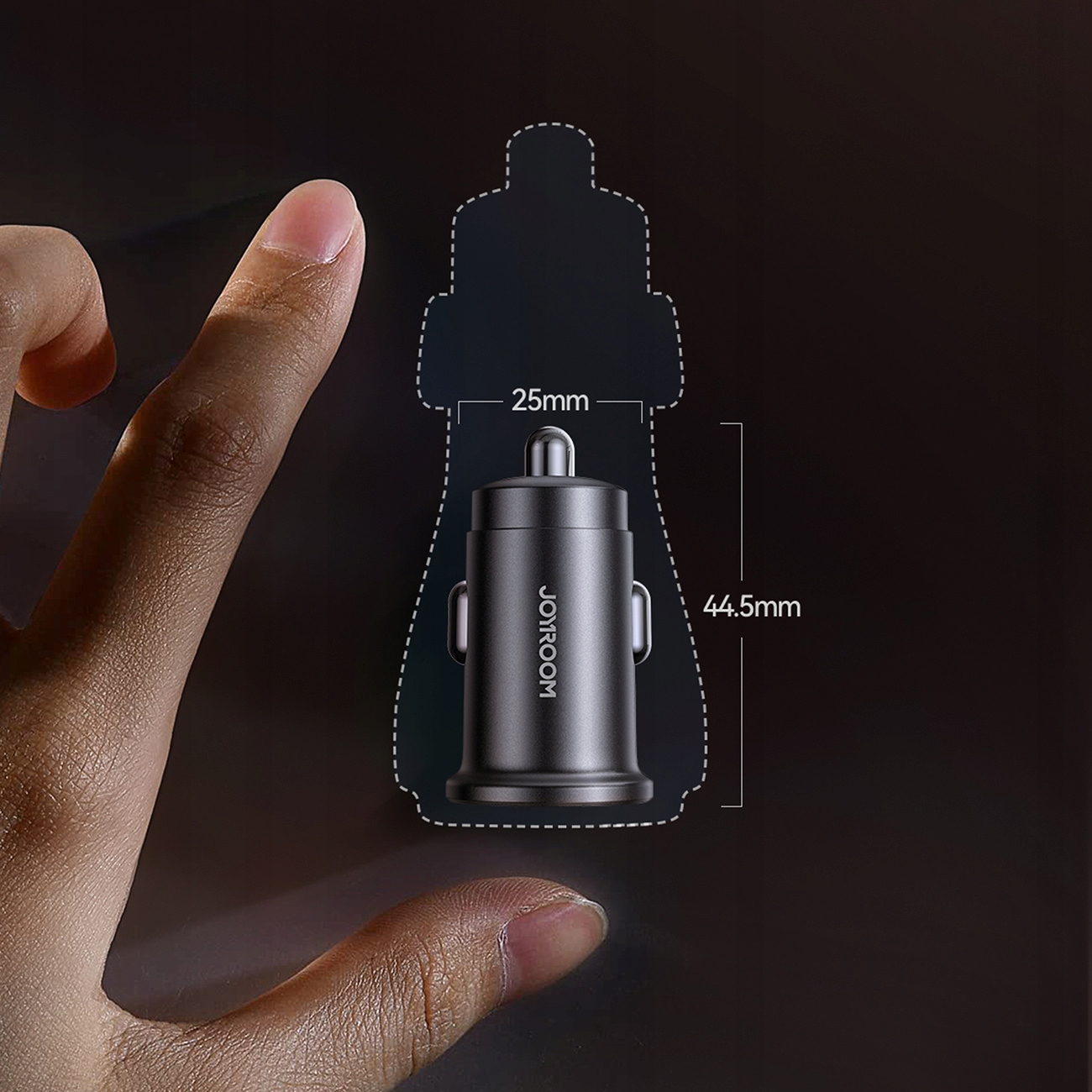 Szara ładowarka samochodowa o wymiarach 25 mm x 44,5 mm pokazana obok palca.