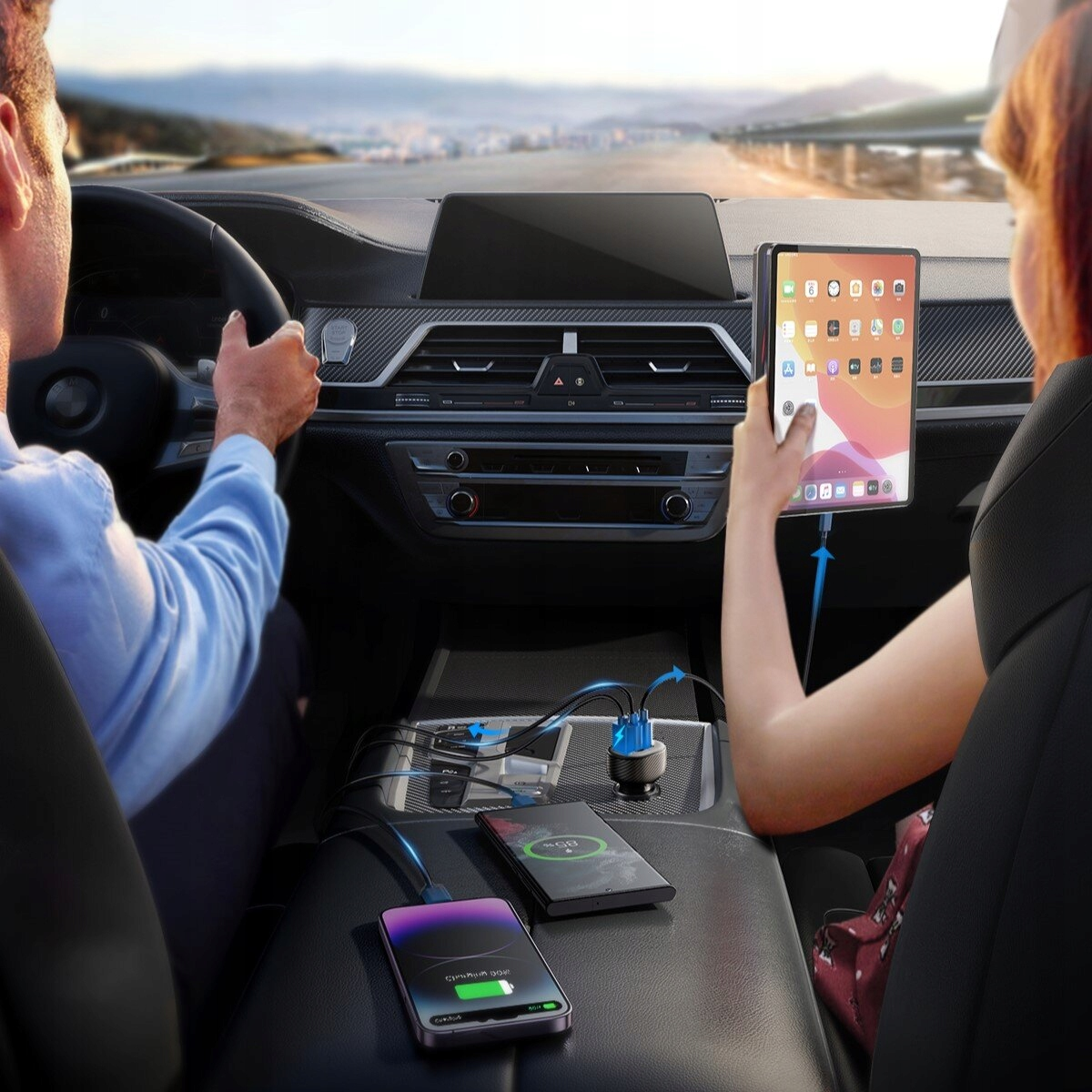Osoba korzystająca z tabletu i telefonu w samochodzie, oba ładujące się za pomocą ładowarek Joyroom.
