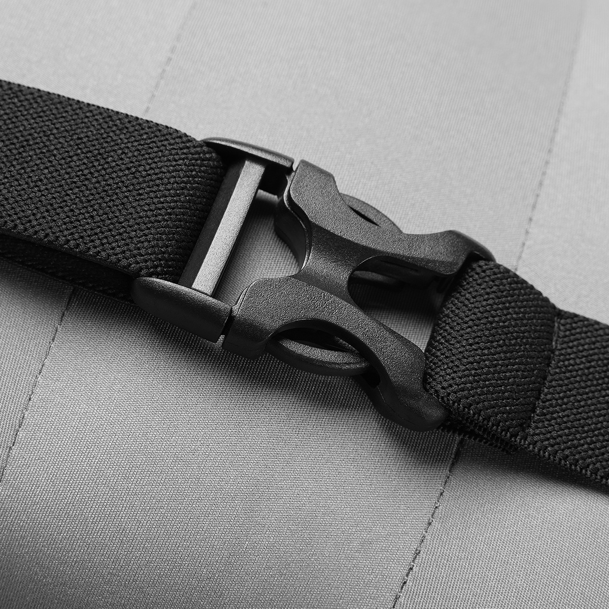 Czarna klamra na szarym pasku. Pasek jest tkany i ma solidną klamrę.