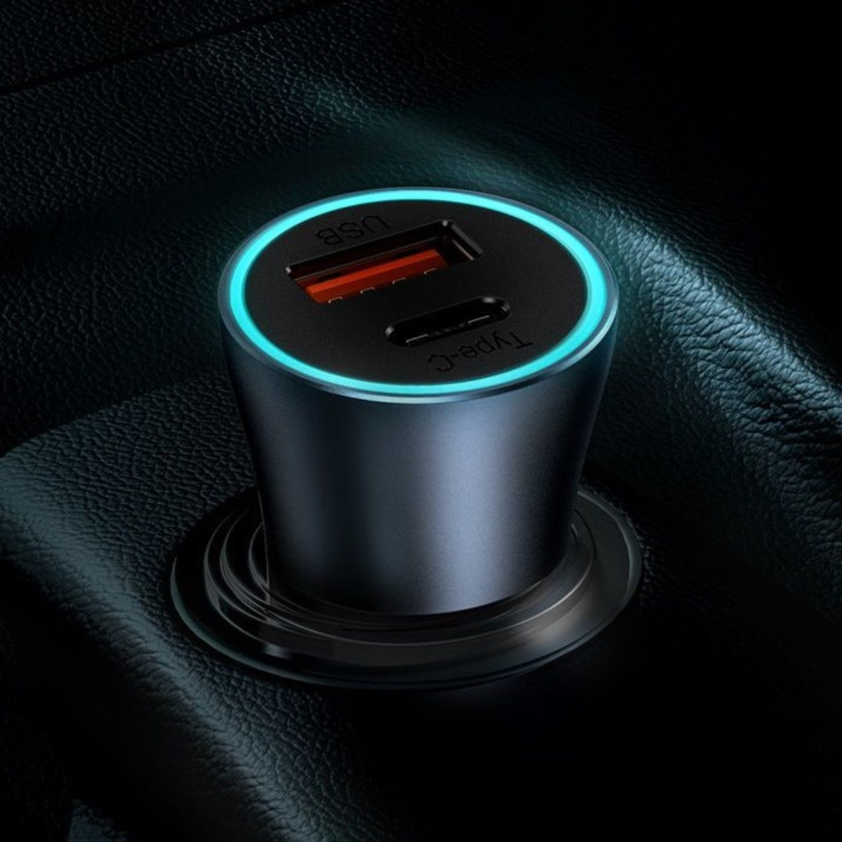 Szara ładowarka samochodowa z portami USB i Type-C, oświetlona niebieskim pierścieniem.