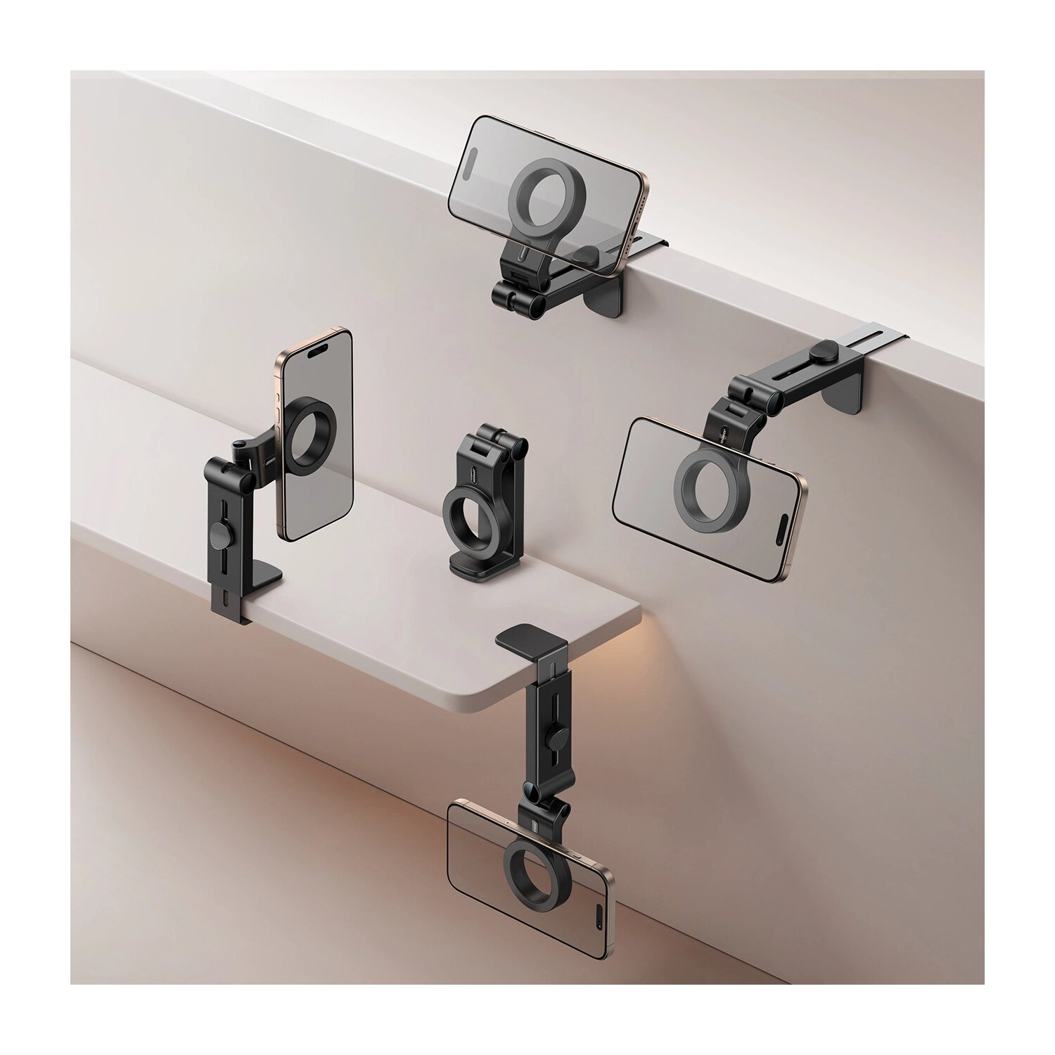Wiele czarnych uchwytów na telefon Joyroom jest przymocowanych do telefonów na białej półce.