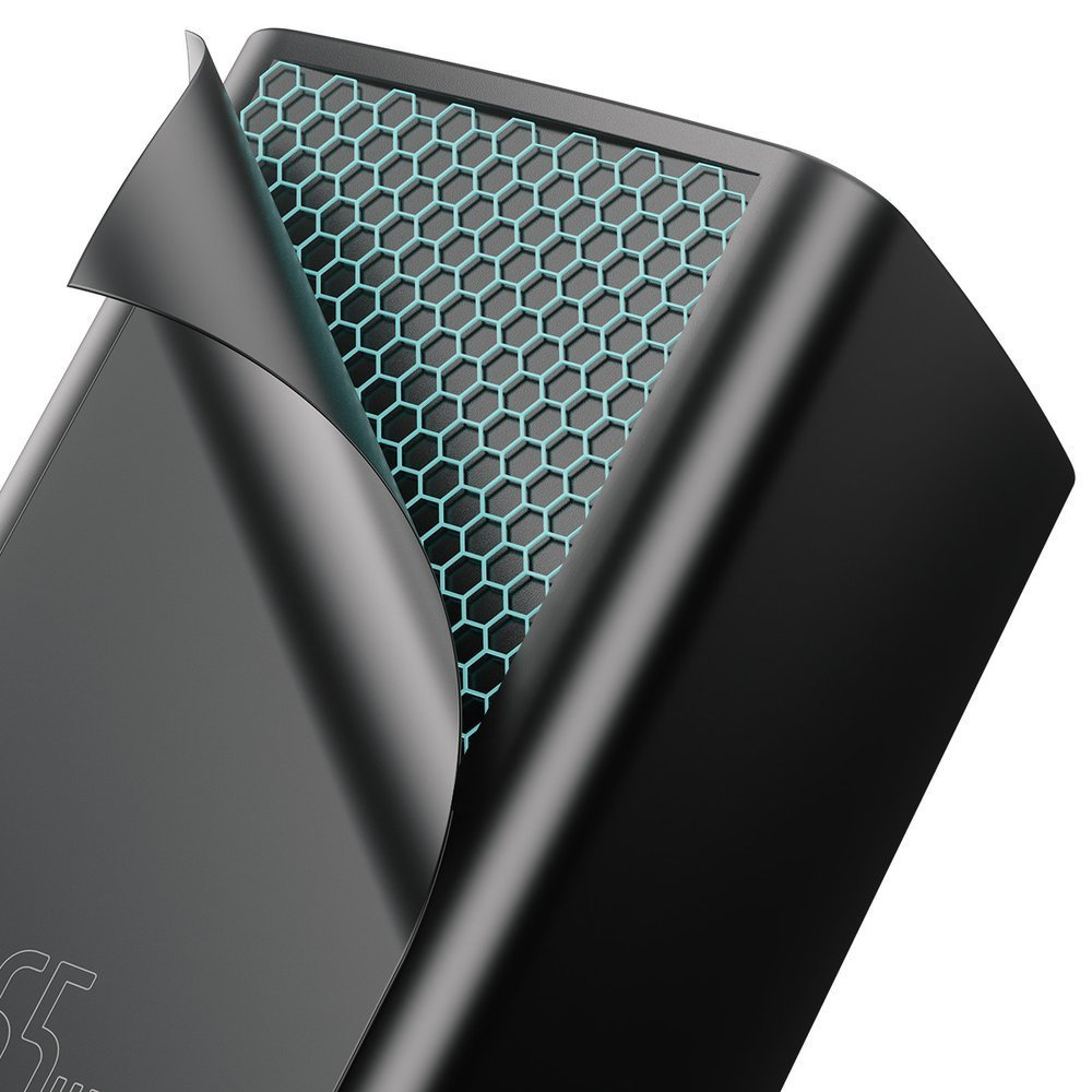 Zbliżenie czarnej ładowarki z wzorem plastra miodu, częściowo pokrytej odrywaną folią.