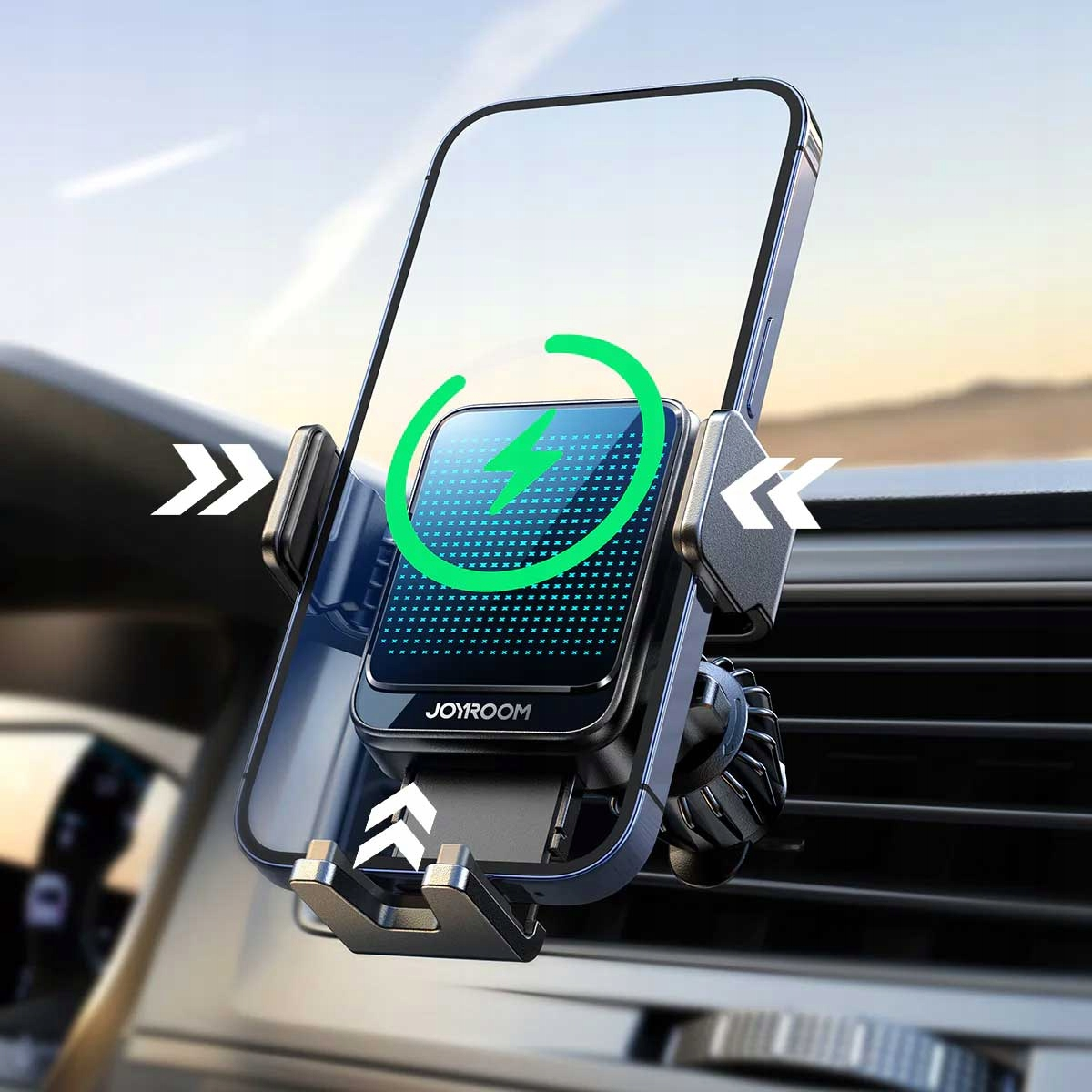 Uchwyt samochodowy do telefonu z telefonem, zamontowany na kratce wentylacyjnej, wyświetlający animację ładowania. W tle niebo.