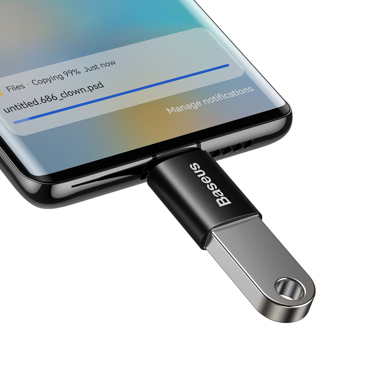 Une clé USB Baseus noire et argentée est connectée à un téléphone.