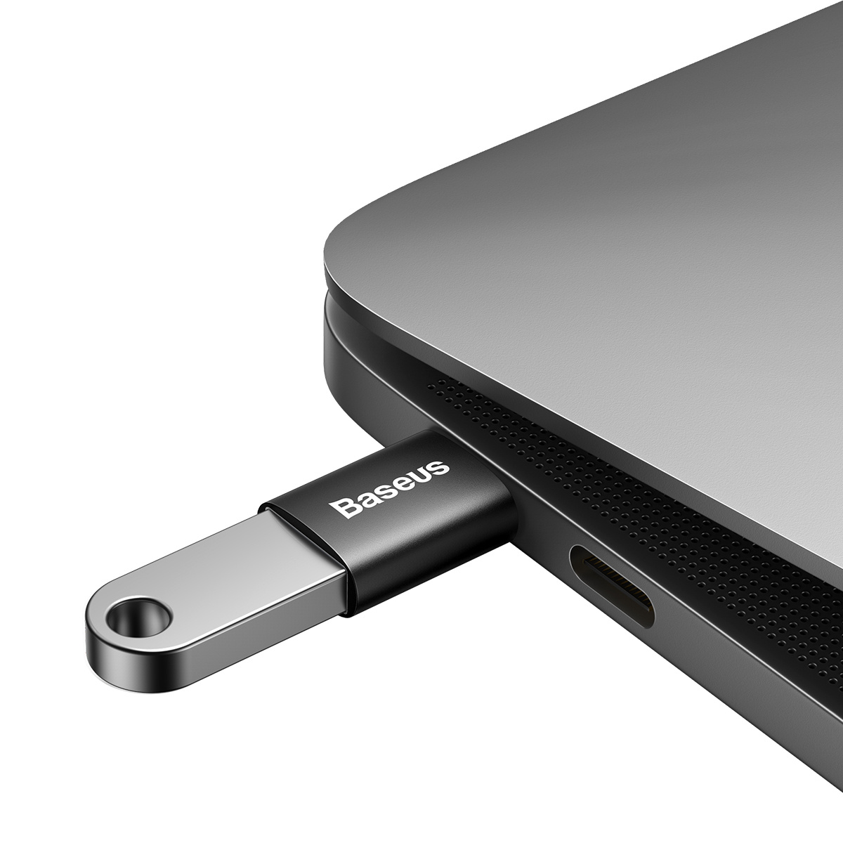 Une clé USB Baseus noire et argentée est branchée sur un ordinateur portable.
