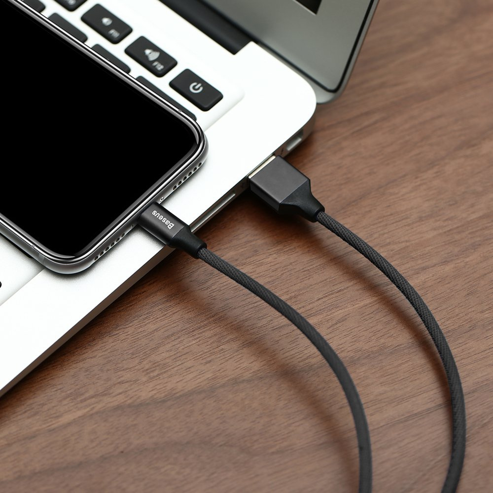 Zdjęcie przedstawia telefon ładowany z laptopa za pomocą czarnego kabla Baseus.