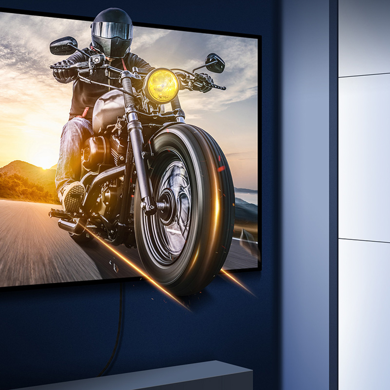 Zdjęcie przedstawia motocykl na ekranie telewizora, zamontowanego na niebieskiej ścianie w pokoju.