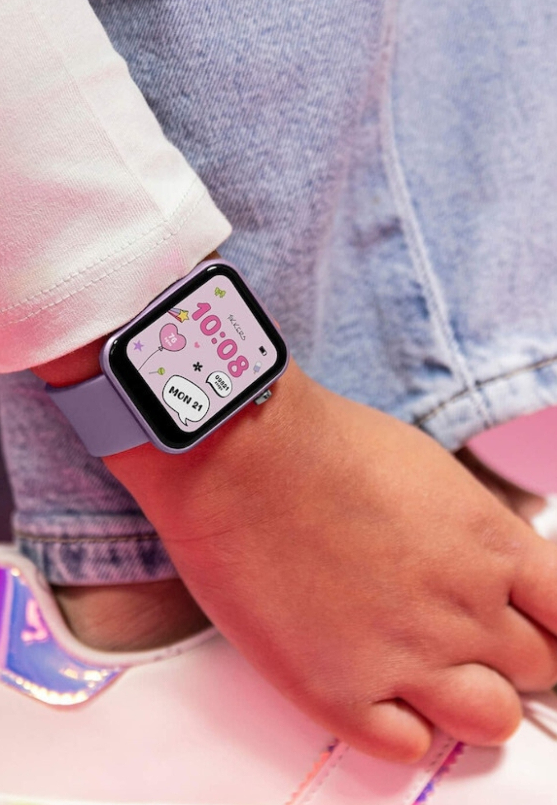 Un polso mostra uno smartwatch lilla che indica le 10:08 sul suo schermo digitale, con grafica da cartone animato.