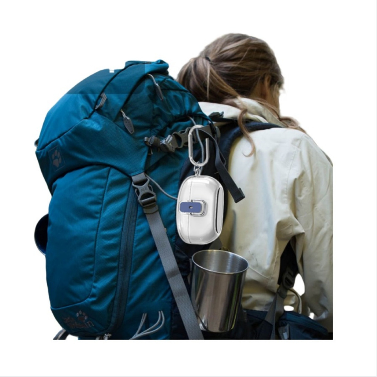 Eine Frau wandert mit einem blauen Rucksack, an dem eine weiße Hülle und ein silberner Becher befestigt sind.
