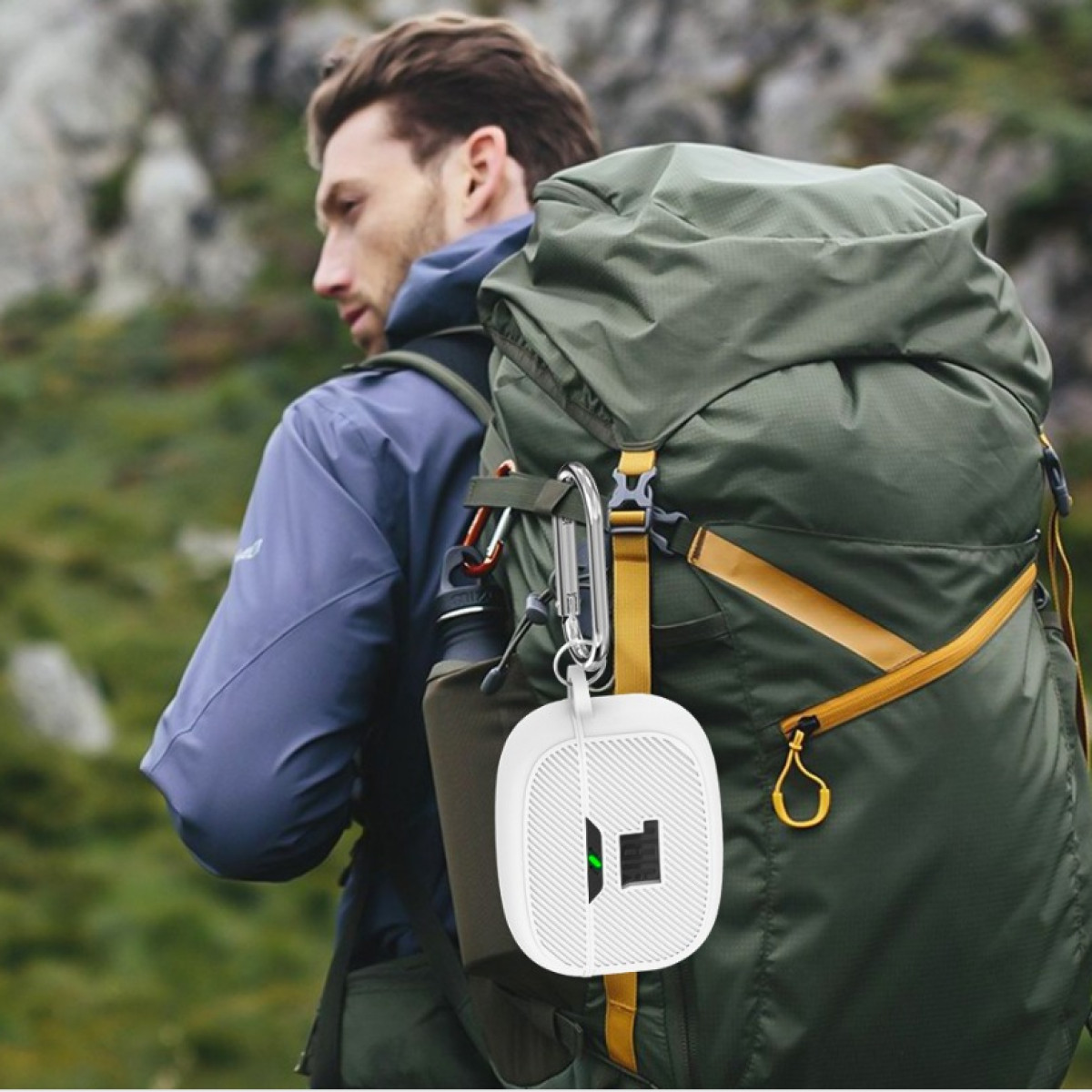 Mann mit Rucksack hält weißes Kopfhörer-Etui mit Karabiner.