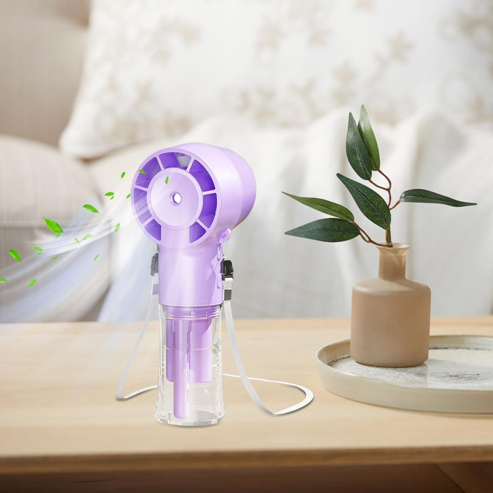 Lila tragbarer Ventilator auf einem Tisch mit im Hintergrund wehenden Blättern, neben einer Vase mit grünen Blättern.