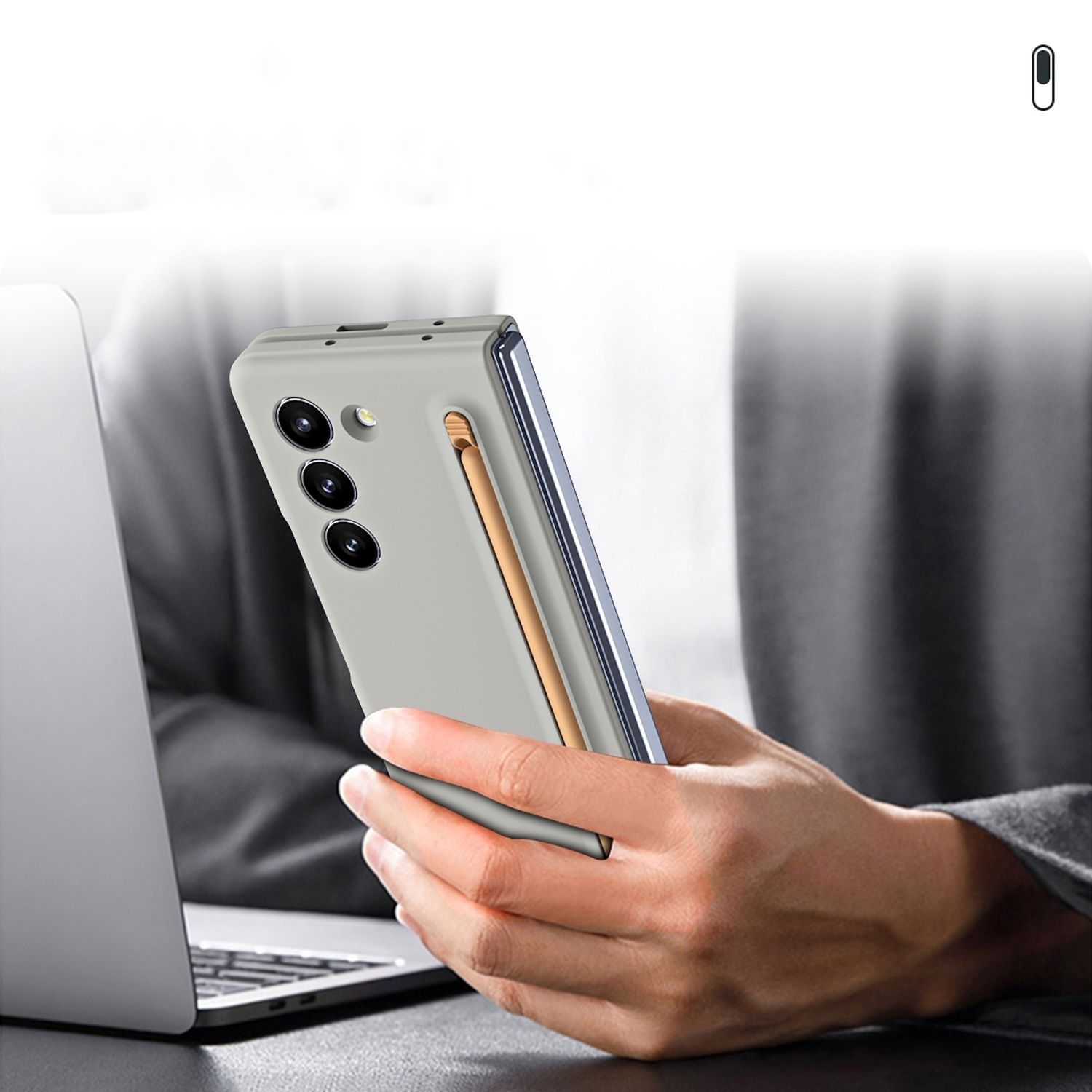 Funda de teléfono con lápiz, sostenida por persona cerca de laptop.