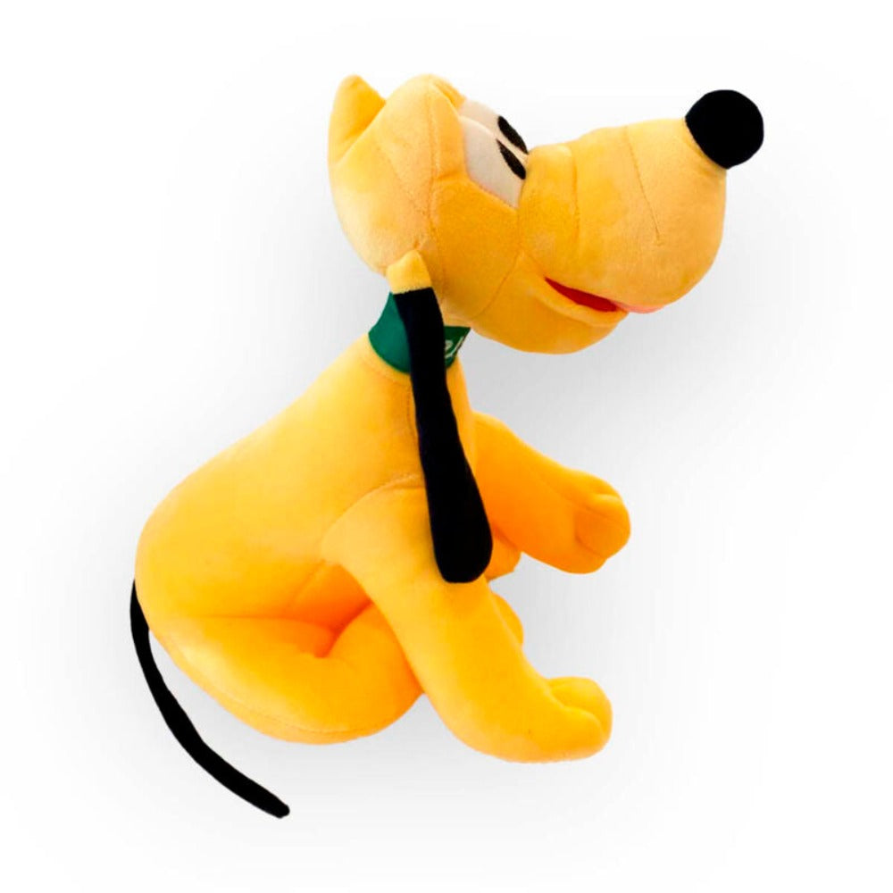 Ein gelbes Pluto-Hundespielzeug aus Plüsch mit schwarzen Ohren und grünem Halsband sitzt vor einem weißen Hintergrund.