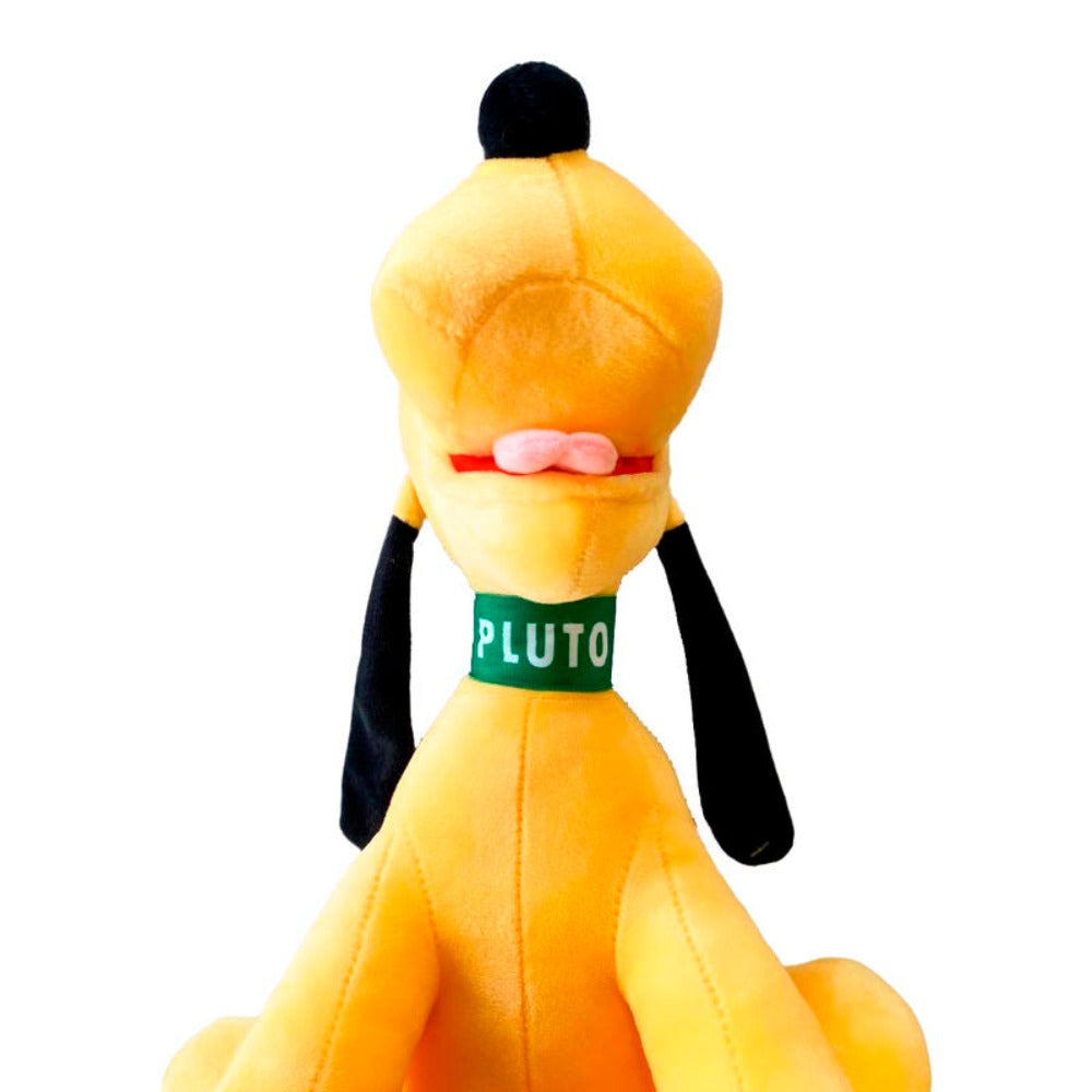 Nahaufnahme eines gelben Pluto-Hundespielzeugs aus Plüsch mit einem grünen Halsband mit der Aufschrift "PLUTO", von hinten gesehen.