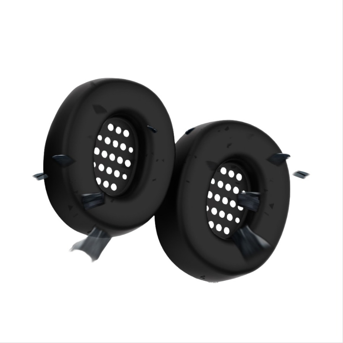 Due cuscinetti auricolari neri con fori perforati sono mostrati su uno sfondo bianco, con alcuni detriti intorno a loro.
