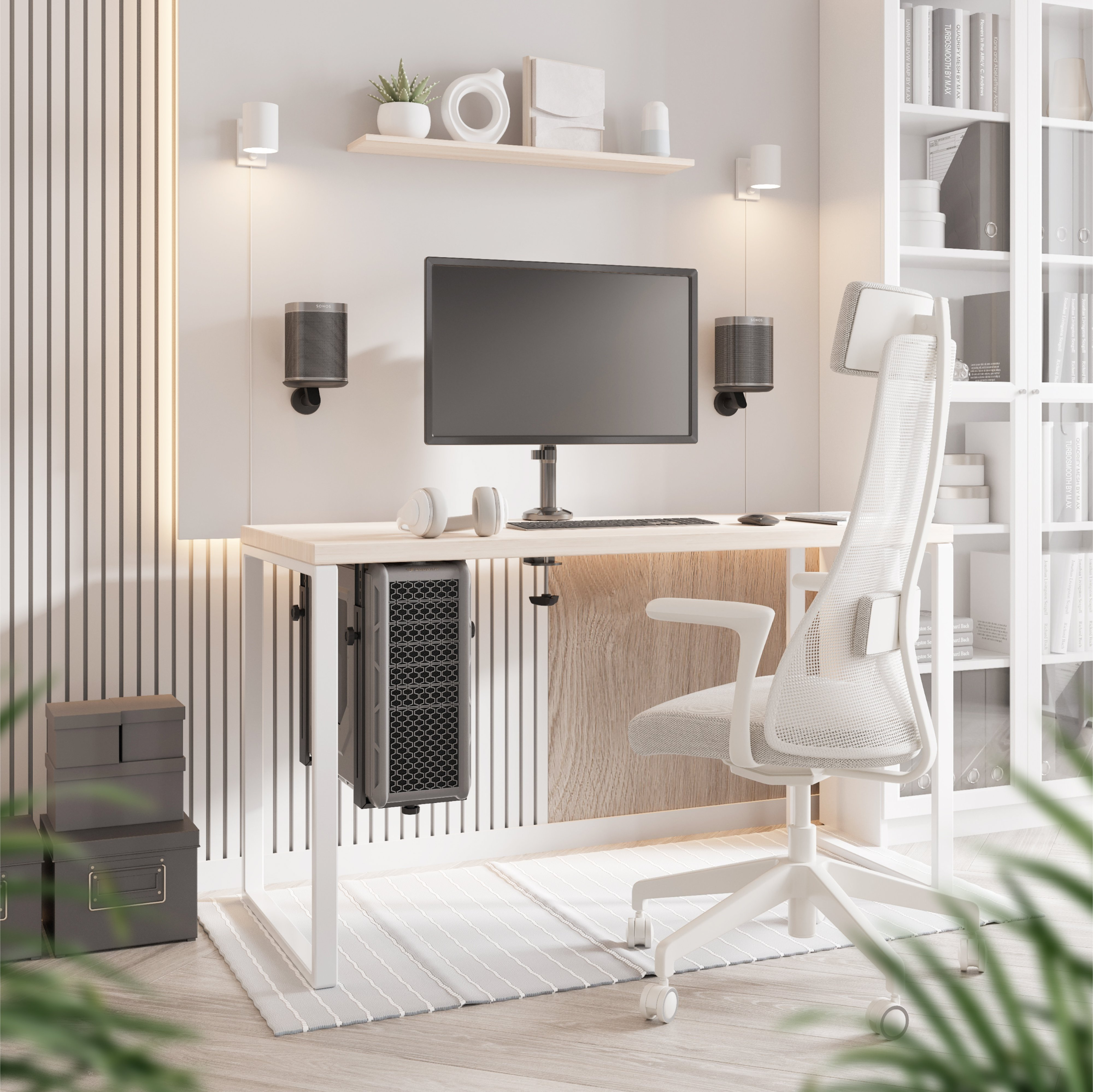 Modernes Homeoffice-Setup mit wandmontierten Lautsprechern, einem Monitor und einem ergonomischen Stuhl.