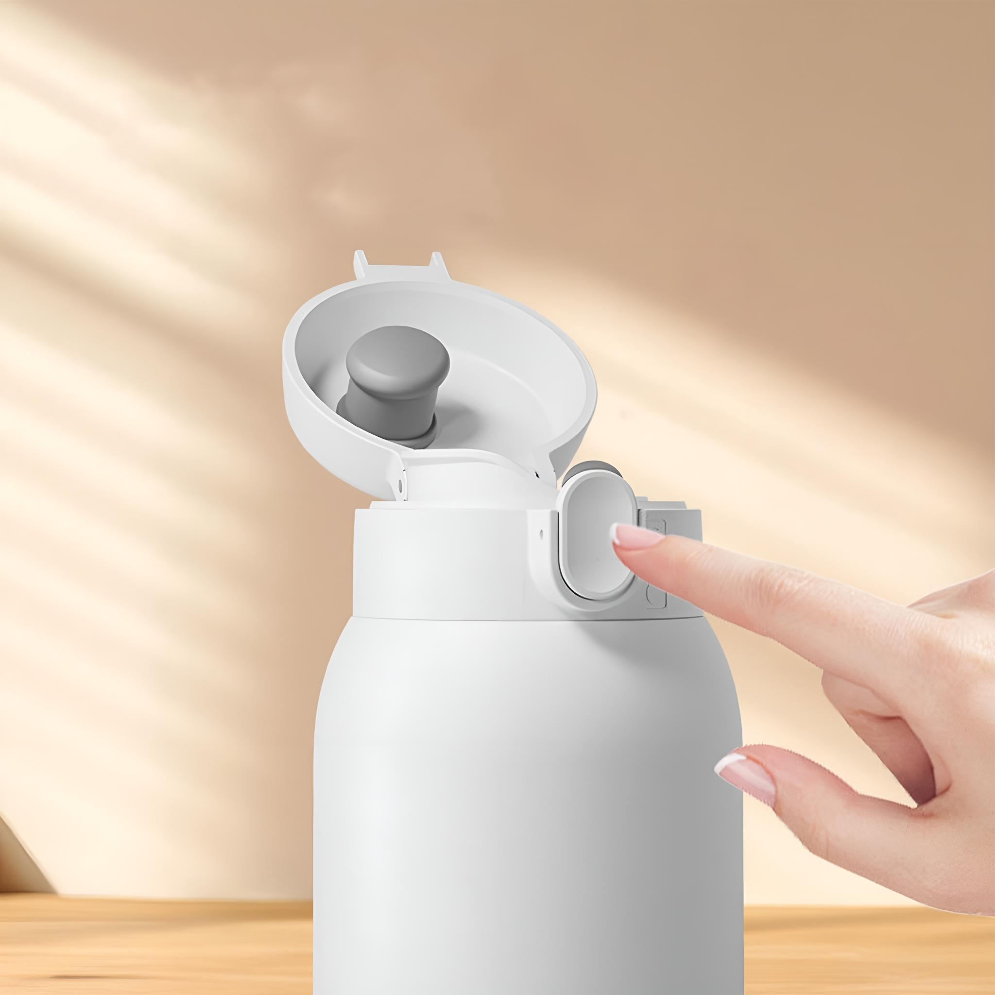 Eine weiße Wasserflasche mit offenem Deckel, die von einer Hand berührt wird. Beiger Hintergrund.