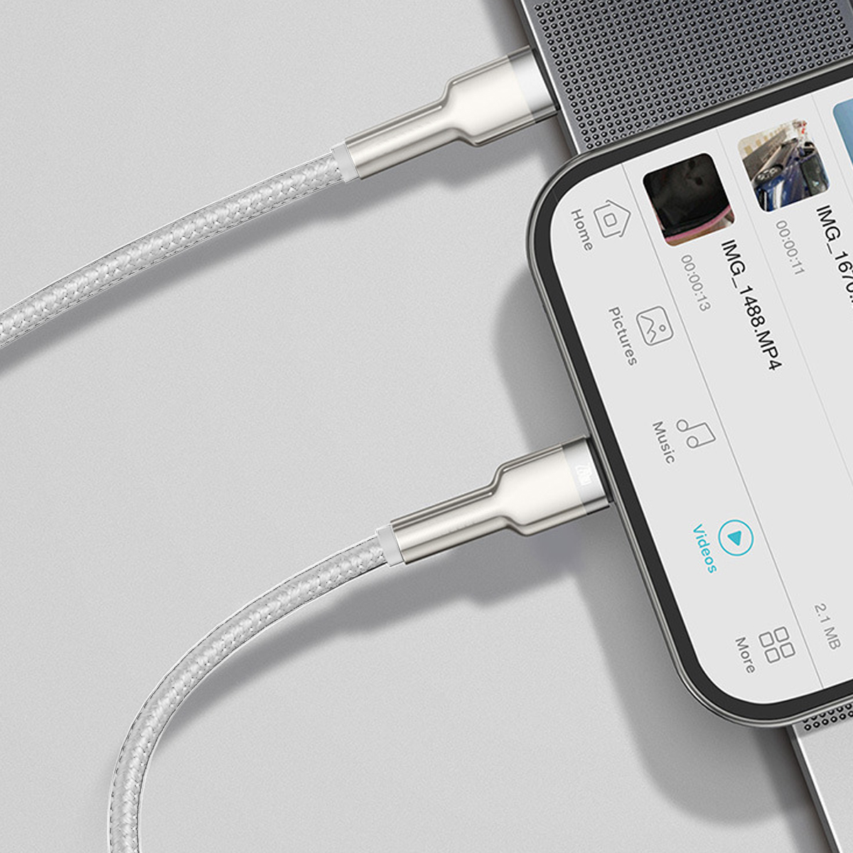Ein Telefon ist mit einem weißen Kabel mit einem Laptop verbunden. Das Telefon zeigt ein Video.