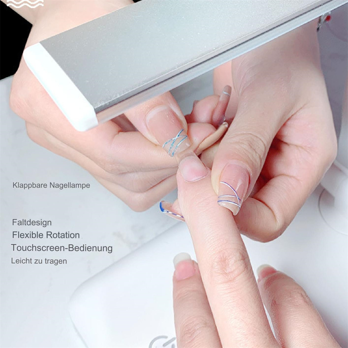 Eine silberne LED-Lampe beleuchtet die Hand einer Frau mit blauer Nagelkunst. Die Hand ruht auf einer weißen Basis.