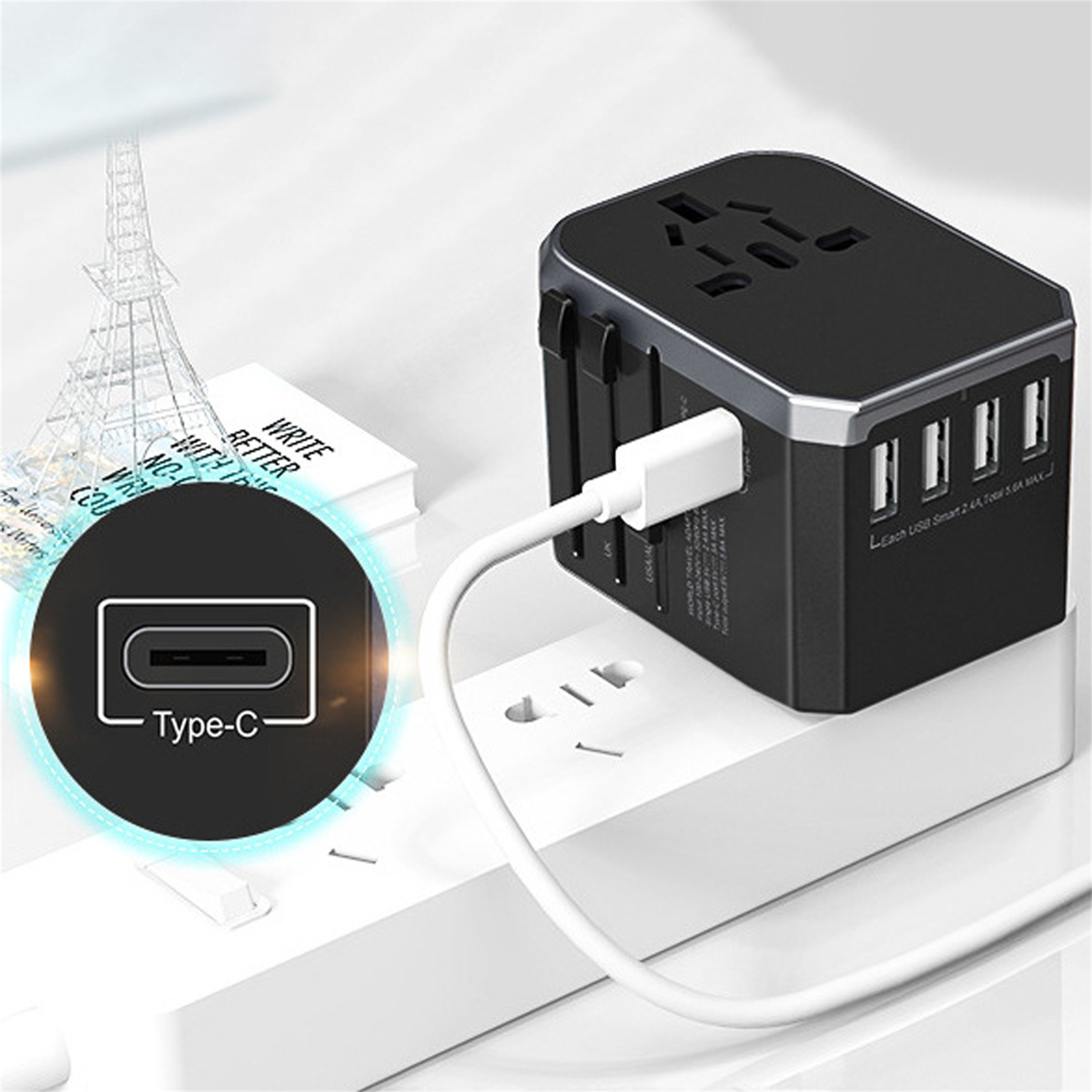 Schwarzer Reiseadapter in eine weiße Steckdose gesteckt, mit eingestecktem Typ-C-Kabel. Eiffelturm im Hintergrund.