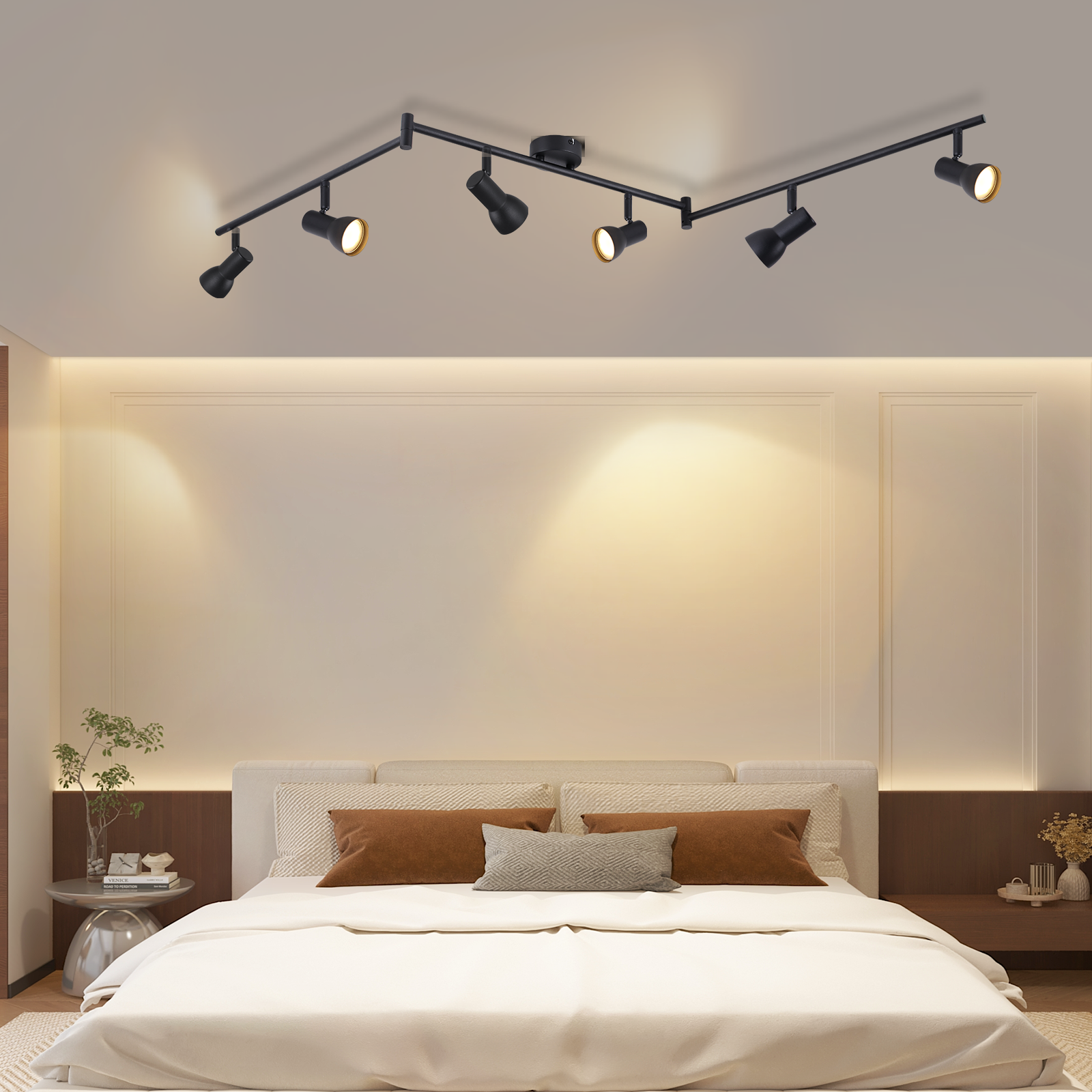 Una camera da letto con un letto con cuscini marroni, illuminata da un'illuminazione a binario nera su un soffitto bianco.