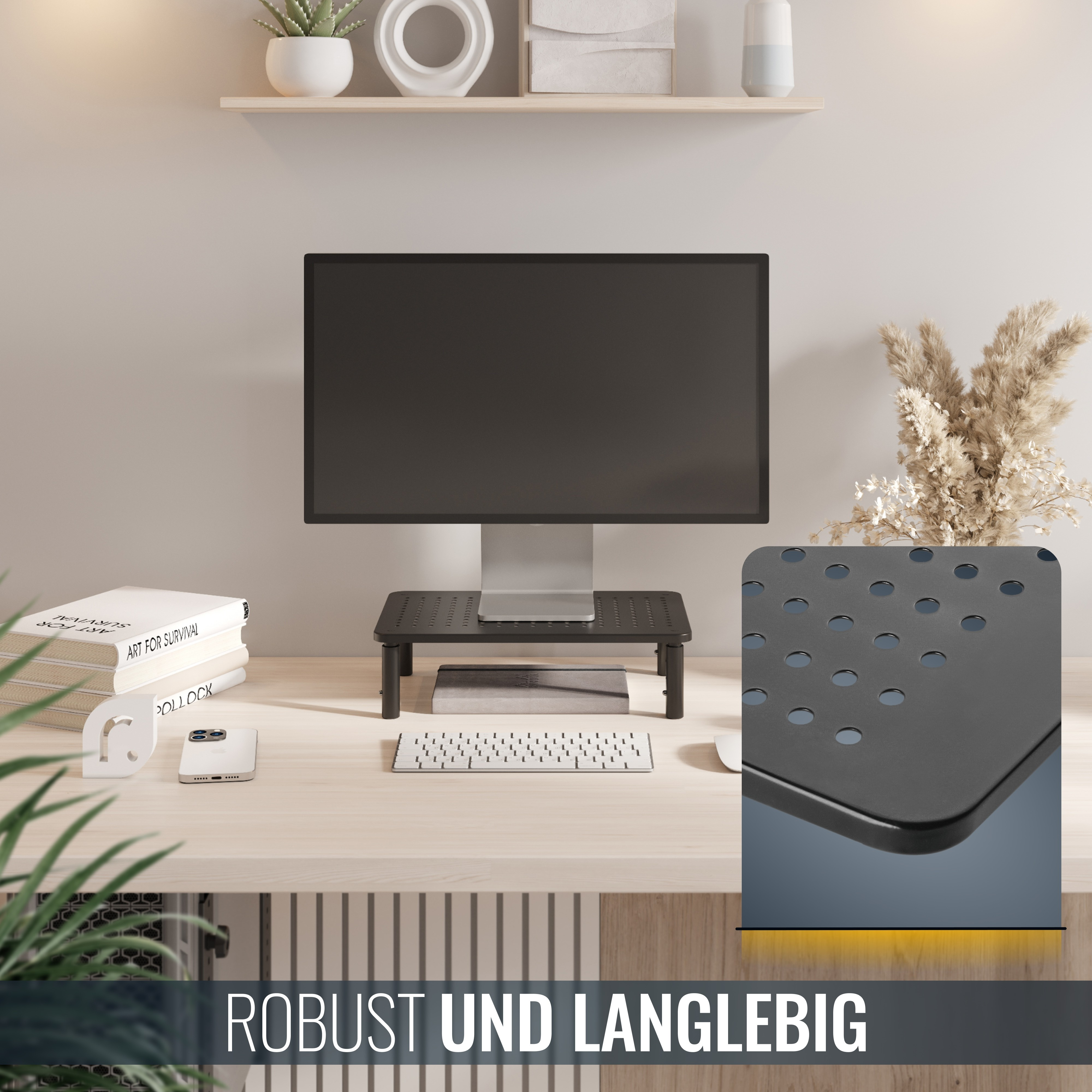 Ein Monitor auf einem schwarzen Ständer steht auf einem Schreibtisch mit Büchern, einer Tastatur, einer Maus und einer Pflanze. Der Ständer hat Löcher.