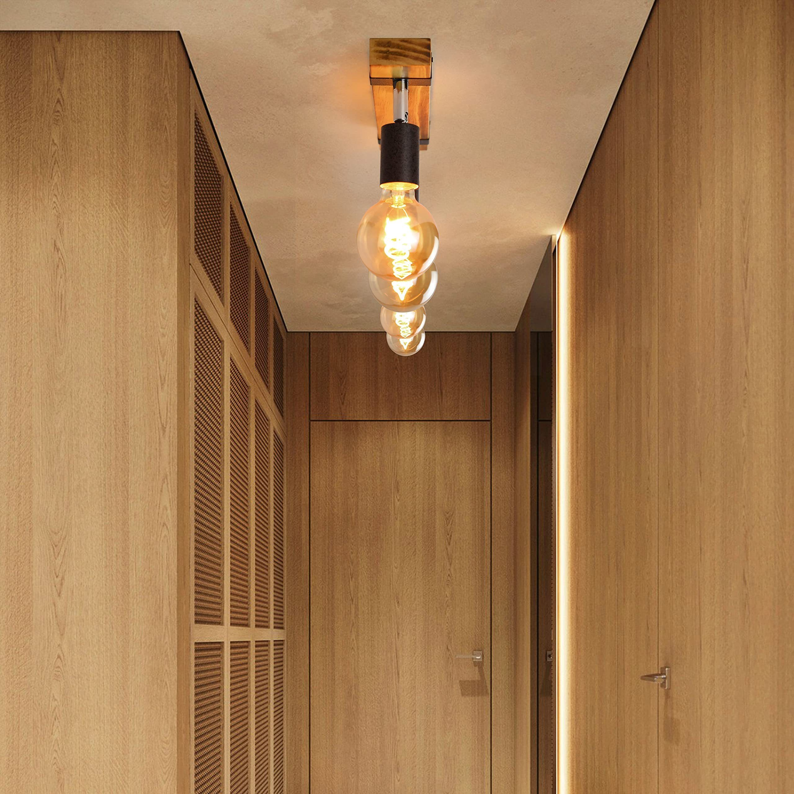 Ein Flur mit Holzwänden und -decke verfügt über eine Leuchte mit vier freiliegenden Glühbirnen.