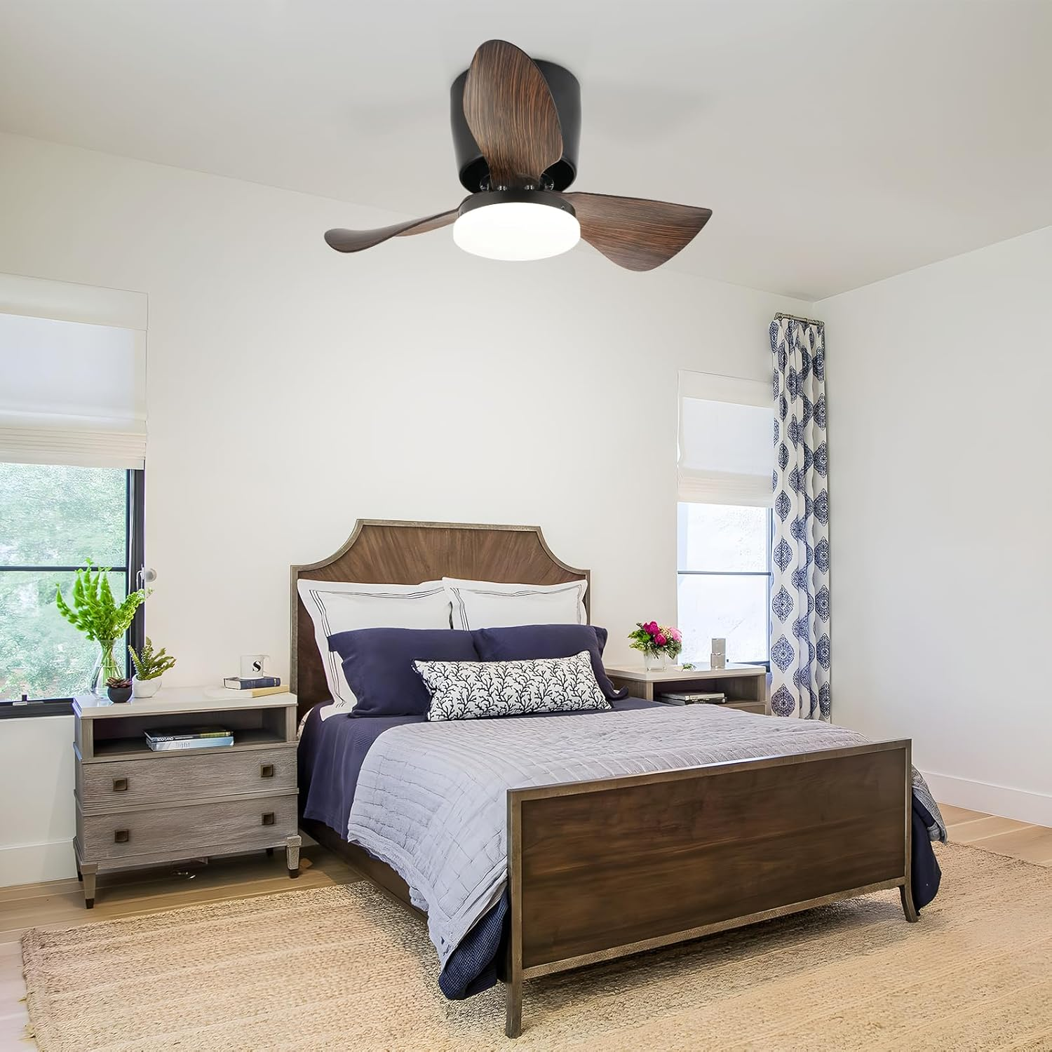 Una camera da letto presenta un letto in legno, un ventilatore a soffitto e un arredamento neutro con accenti blu.
