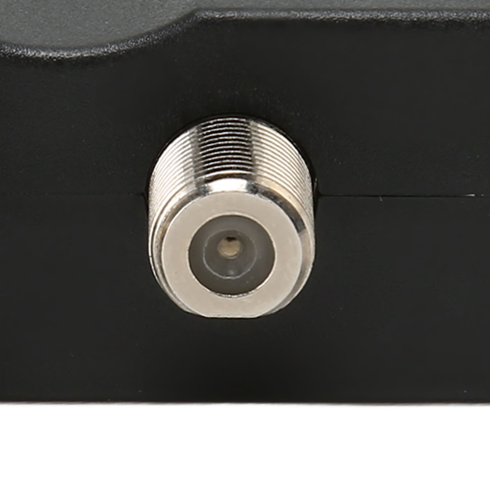 Nahaufnahme eines Koaxialkabelanschlusses an einem schwarzen elektronischen Gerät.