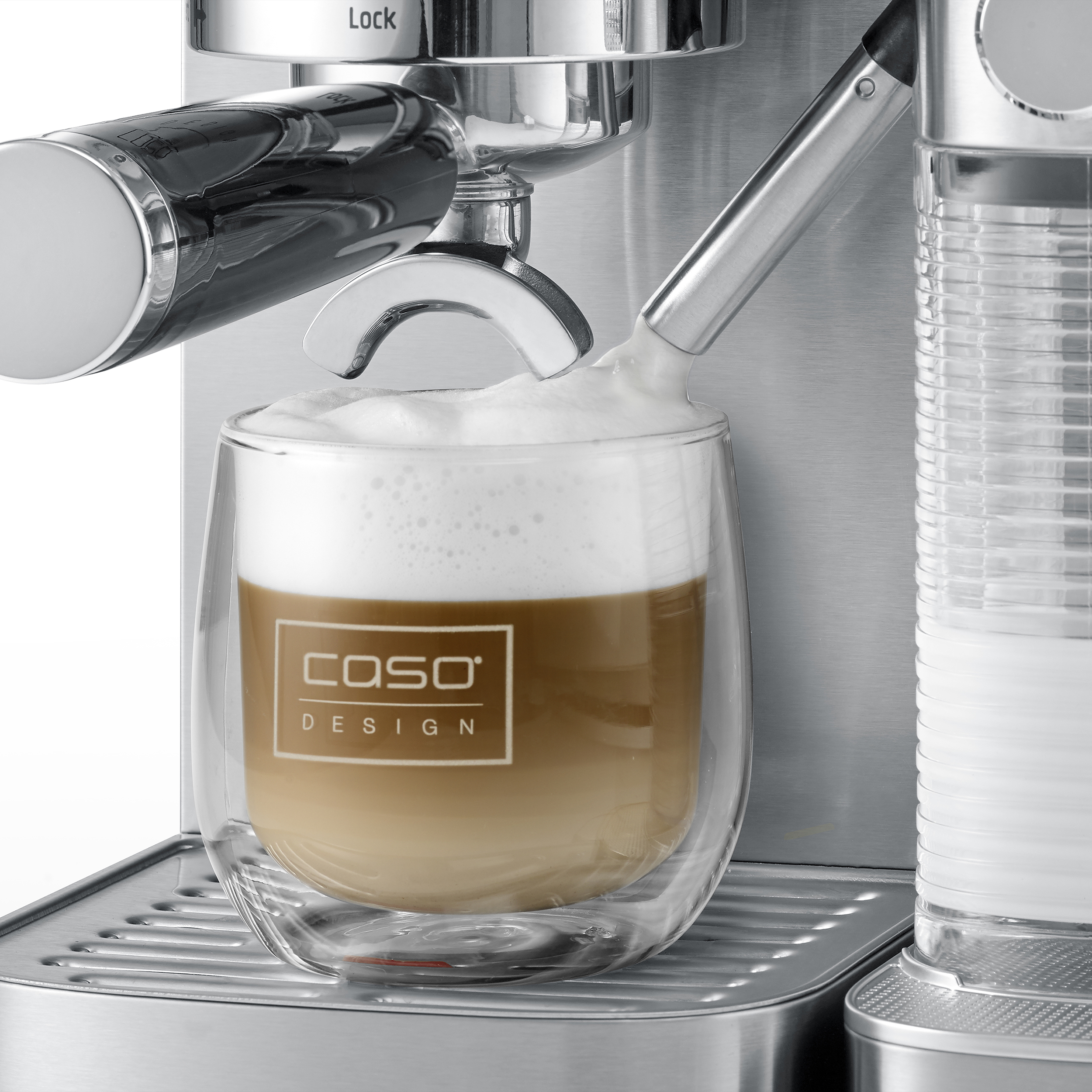Eine Espressomaschine aus Edelstahl gibt einen Latte in eine durchsichtige Glastasse aus.