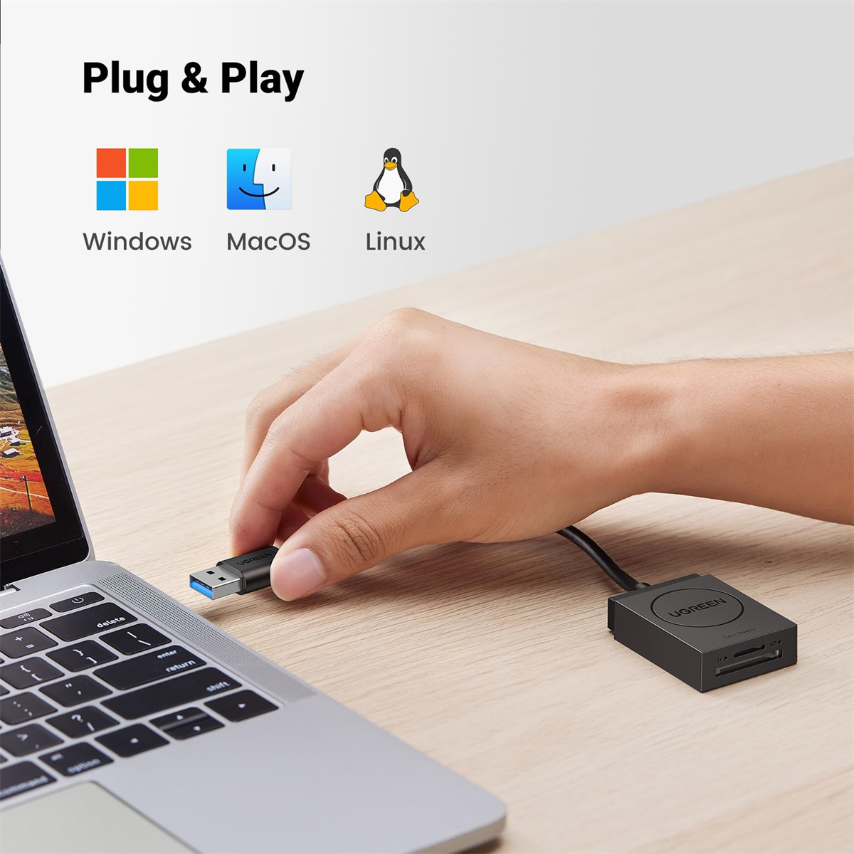 Eine Hand, die einen USB-Kartenleser an einen Laptop anschließt. Symbole zeigen Windows, macOS und Linux.