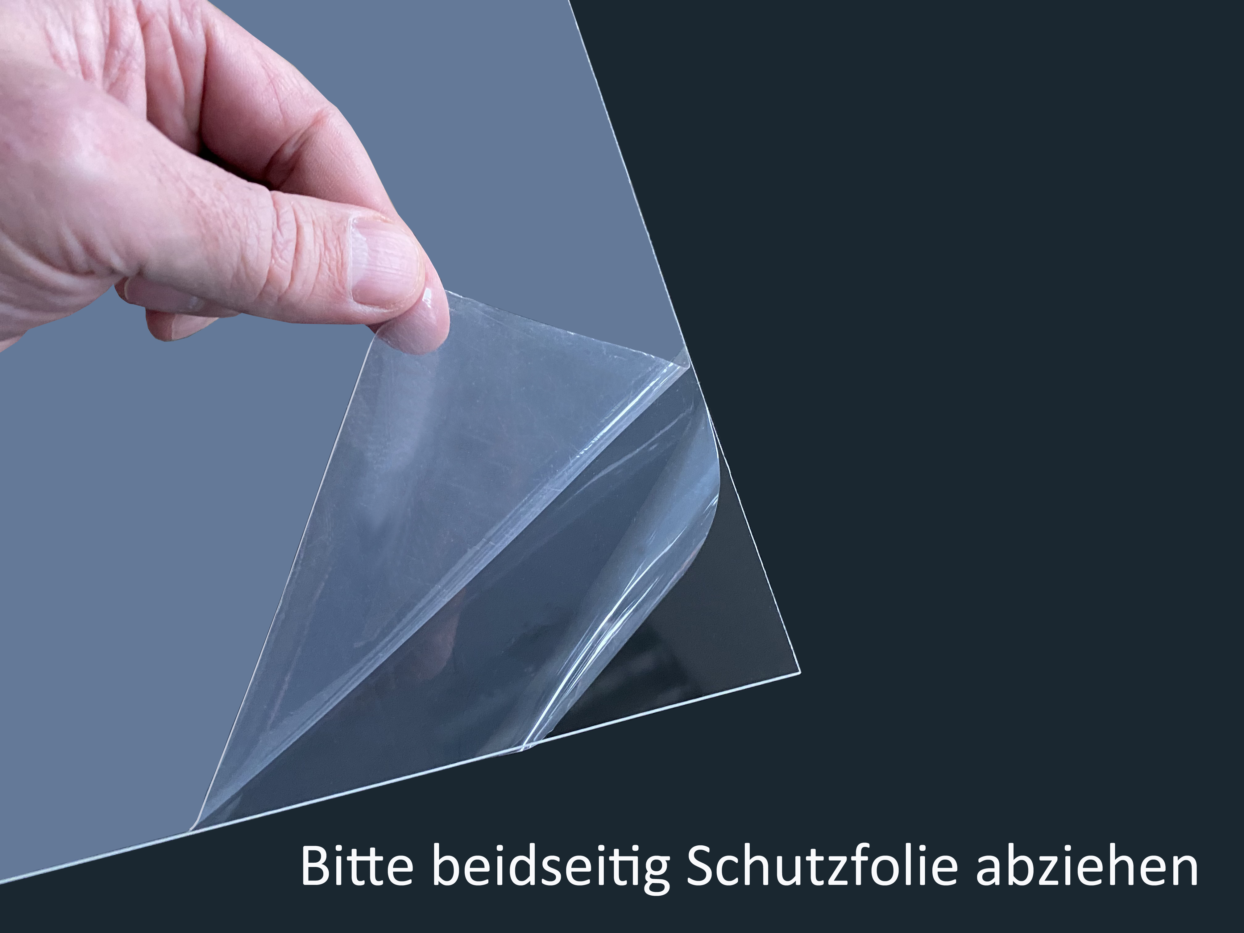 Eine Hand zieht eine Schutzfolie von einer transparenten Kunststofffolie ab.