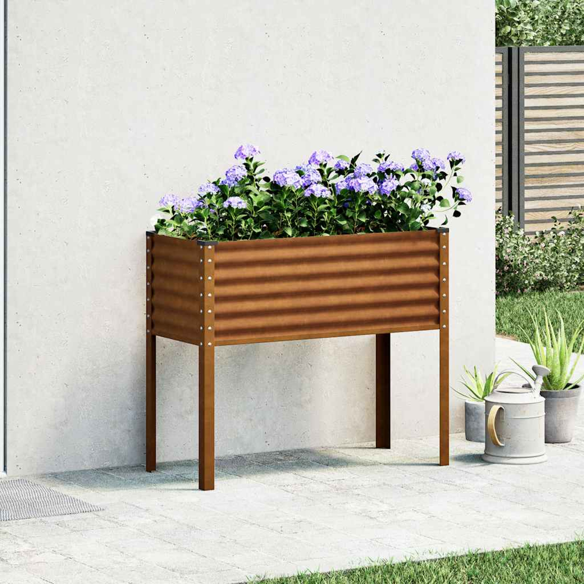 Viene mostrato un letto da giardino rialzato in metallo marrone con fiori viola, un muro bianco e un annaffiatoio grigio.
