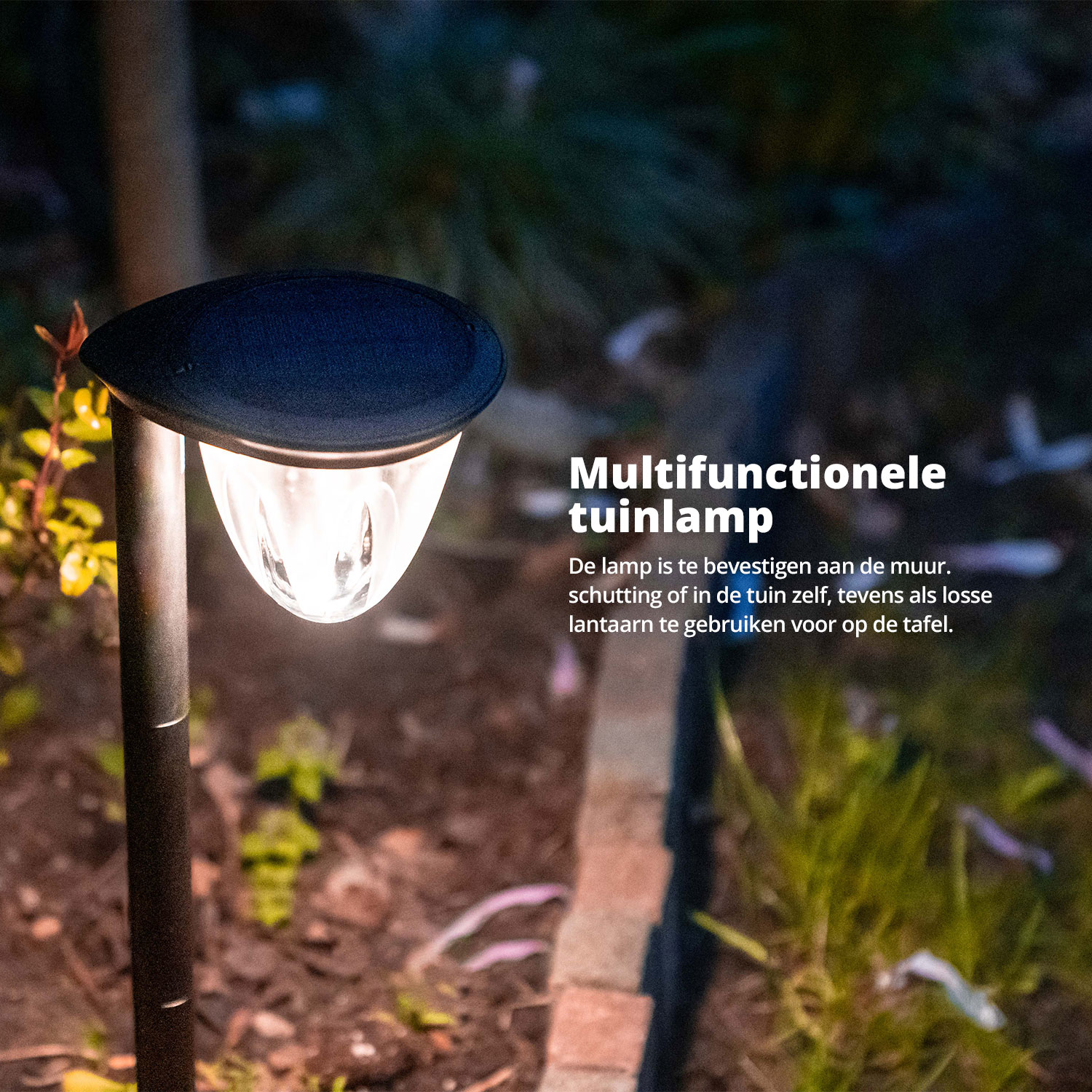 Een zwarte solar buitenlamp staat 's nachts tussen planten in een tuin.
