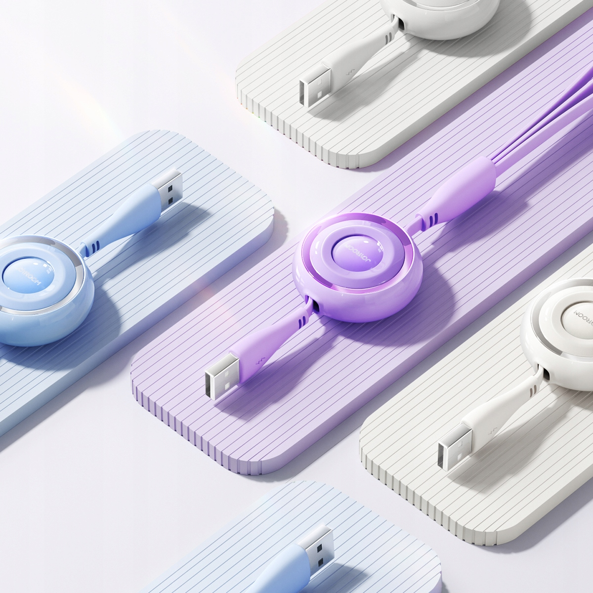 Różne pastelowe zwijane kable ładujące są ułożone na paskowanych powierzchniach, prezentując ich wygląd.