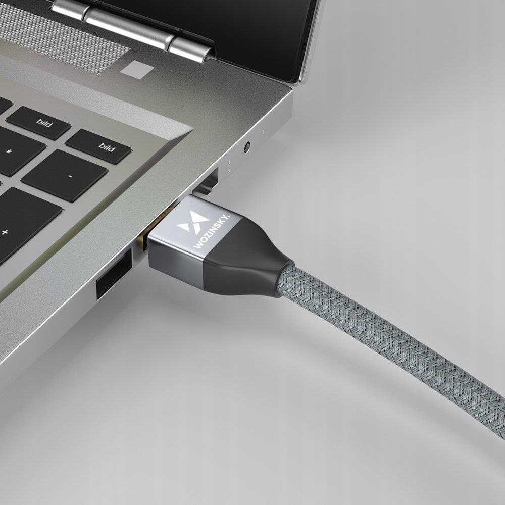 Szary pleciony kabel ze złączem USB-C podłączony do laptopa.