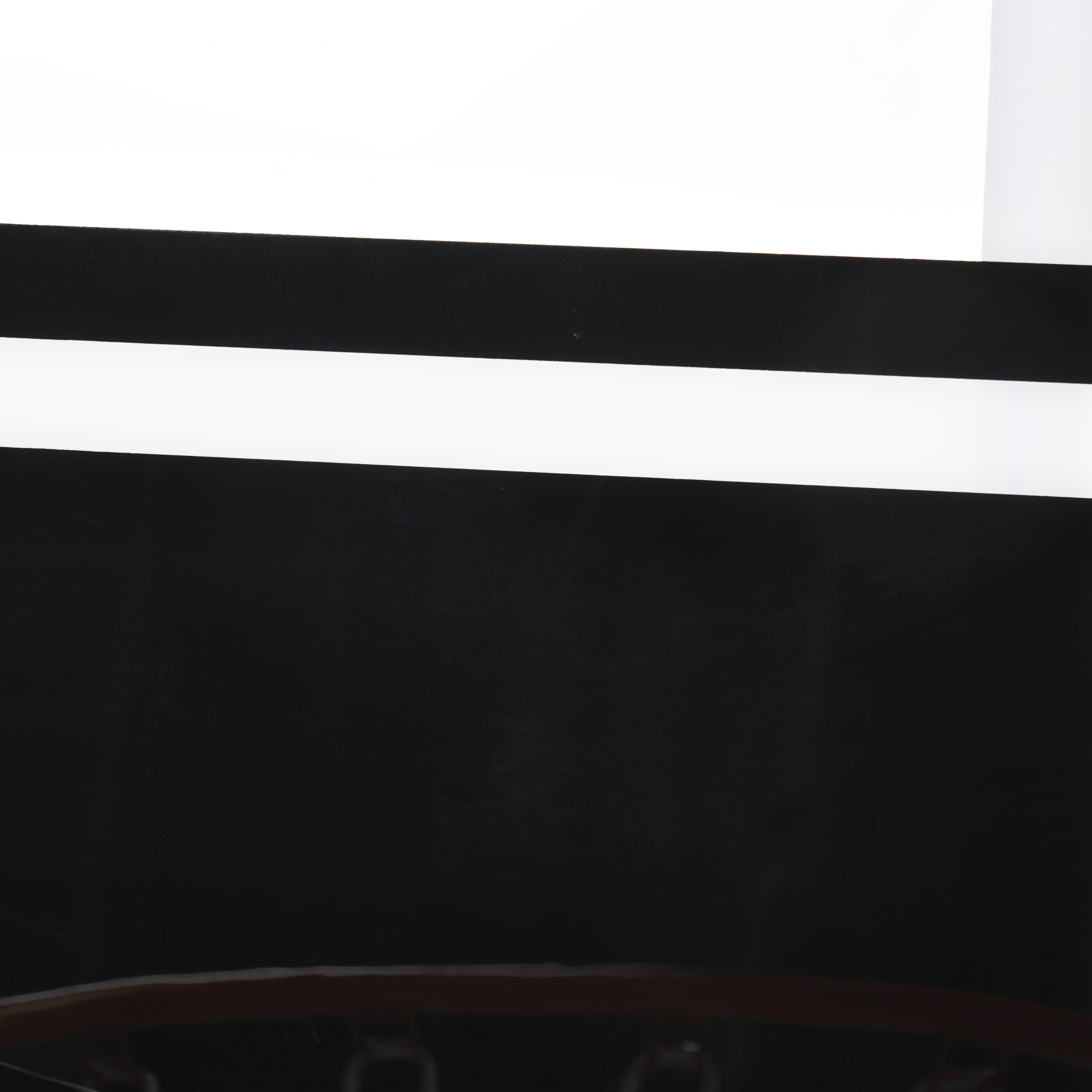 Primer plano de una pared en blanco y negro. Una franja blanca se coloca en el centro de la superficie negra.