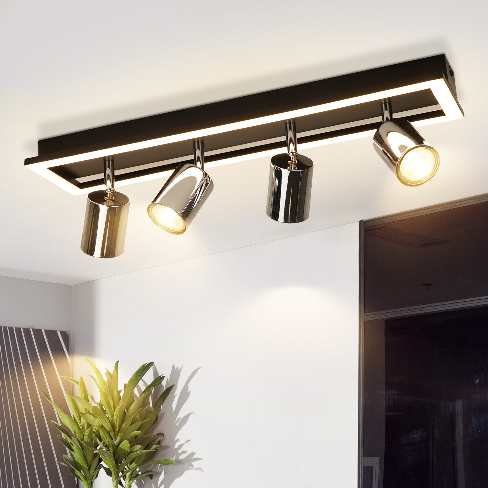 Illuminazione a binario nera e argento con quattro faretti orientabili.