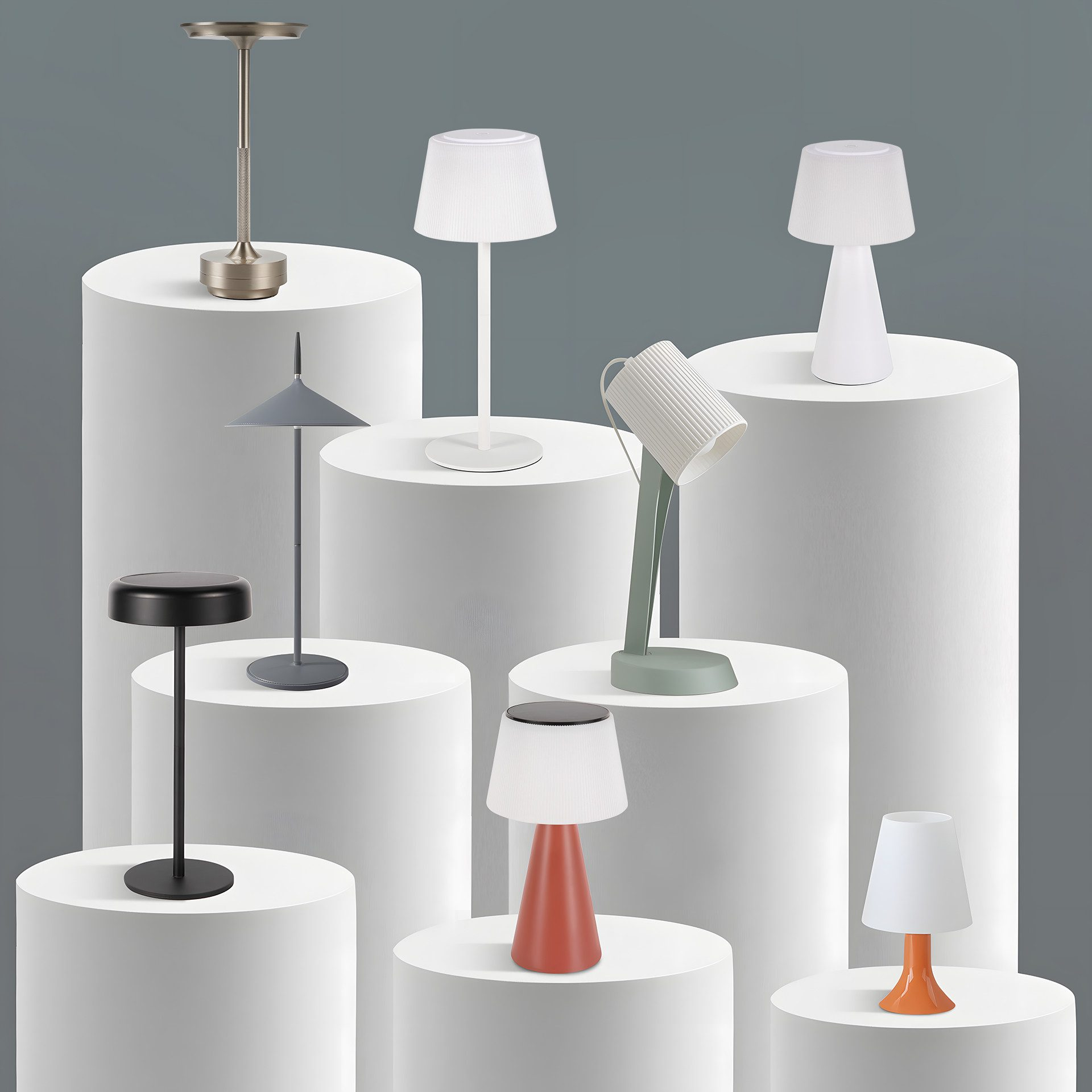 Kolekcja różnych lamp stołowych w różnych stylach i kolorach, ustawionych na białych cylindrycznych stojakach.
