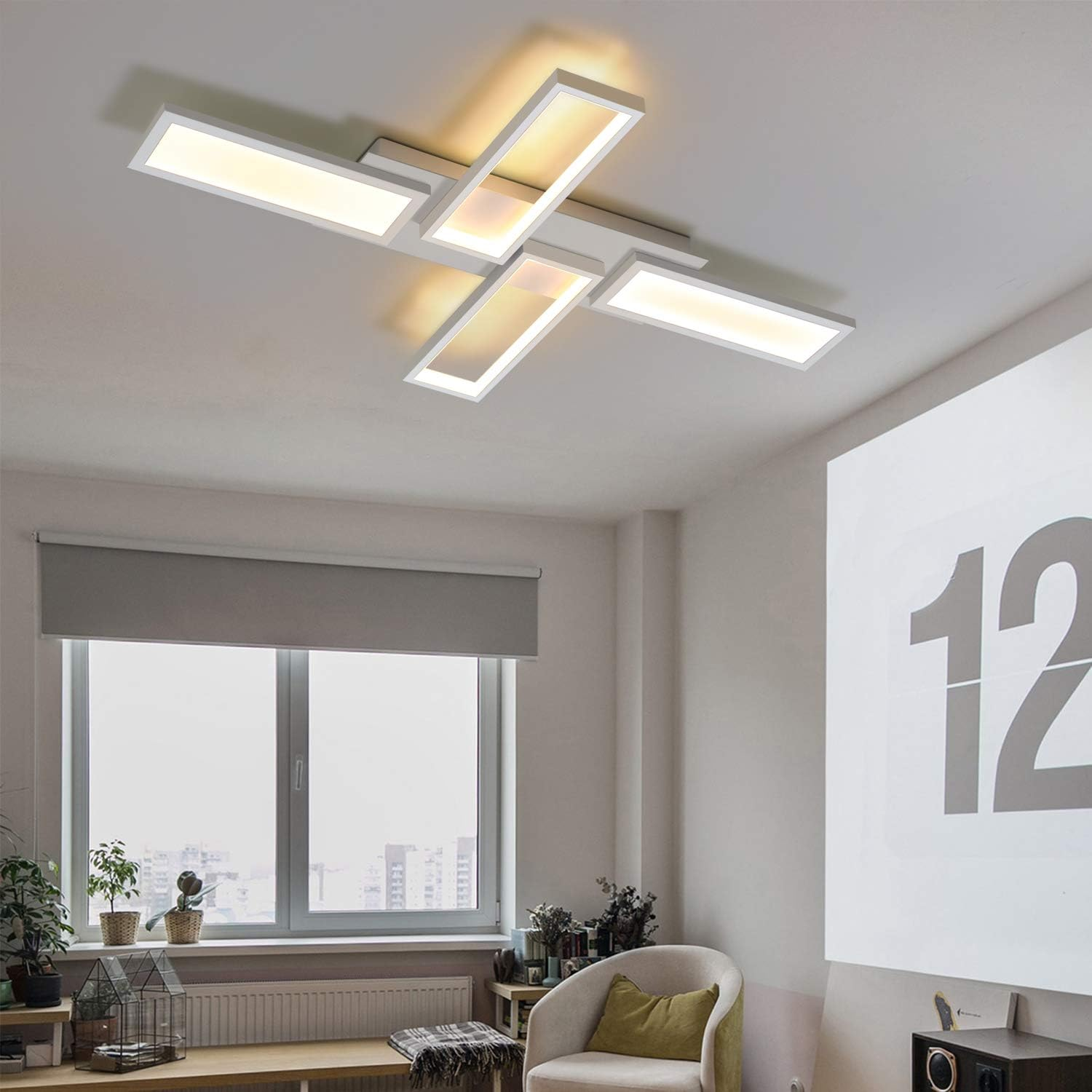 Lampada da soffitto con pannelli intersecanti, che emette luce, in una stanza con grandi finestre.
