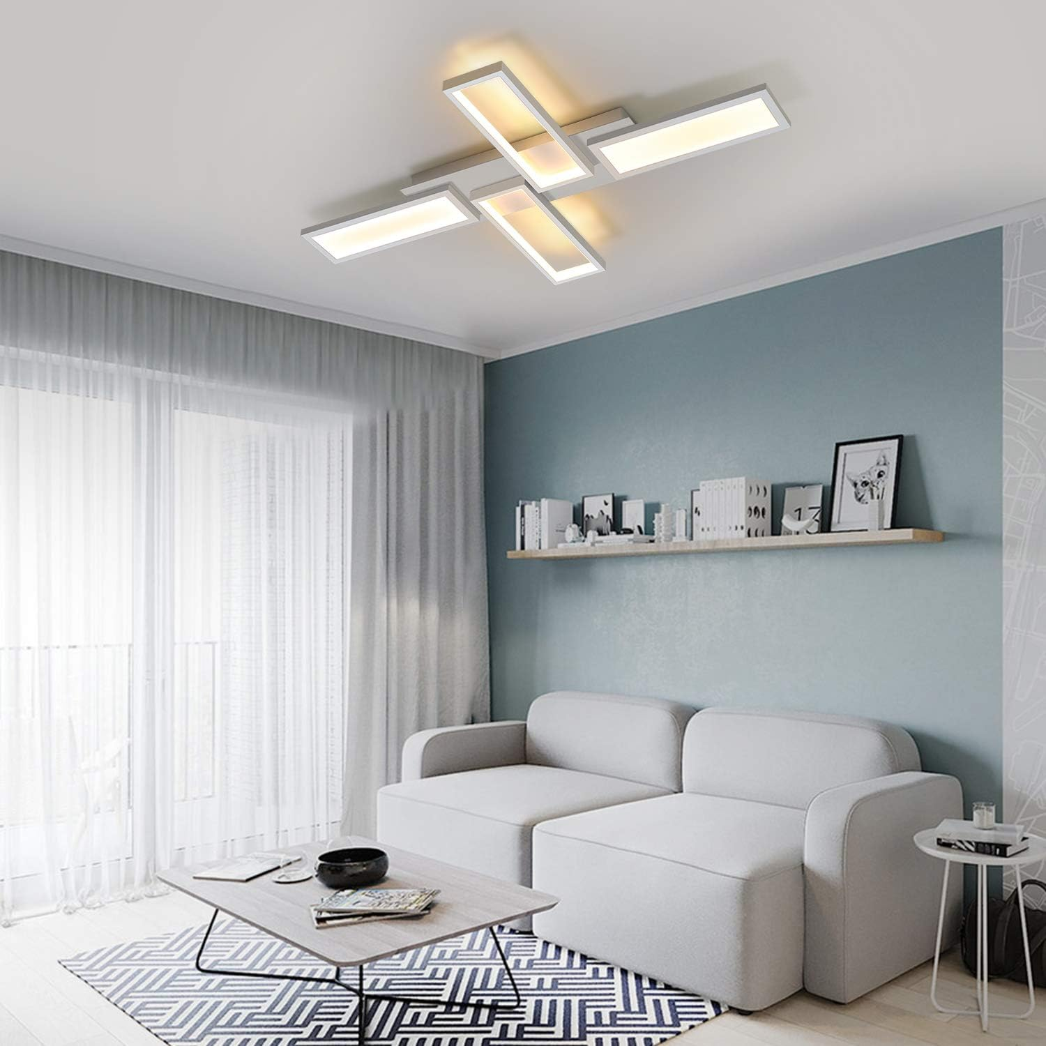 Soggiorno con lampada da soffitto moderna, divano bianco e parete blu con mensola e decorazioni.