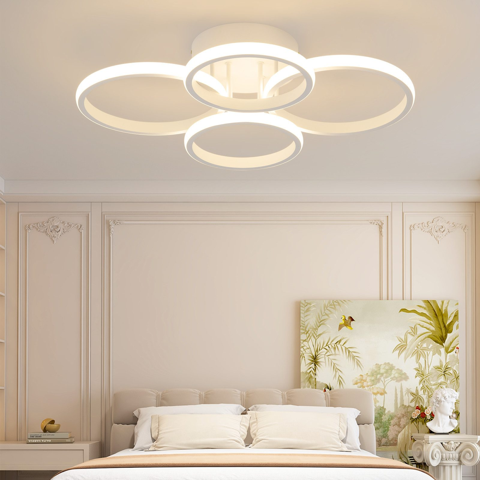Eine weiße Deckenleuchte mit kreisförmigen Designs über einem Bett. Ein Gemälde und eine kleine Statue befinden sich ebenfalls im Raum.