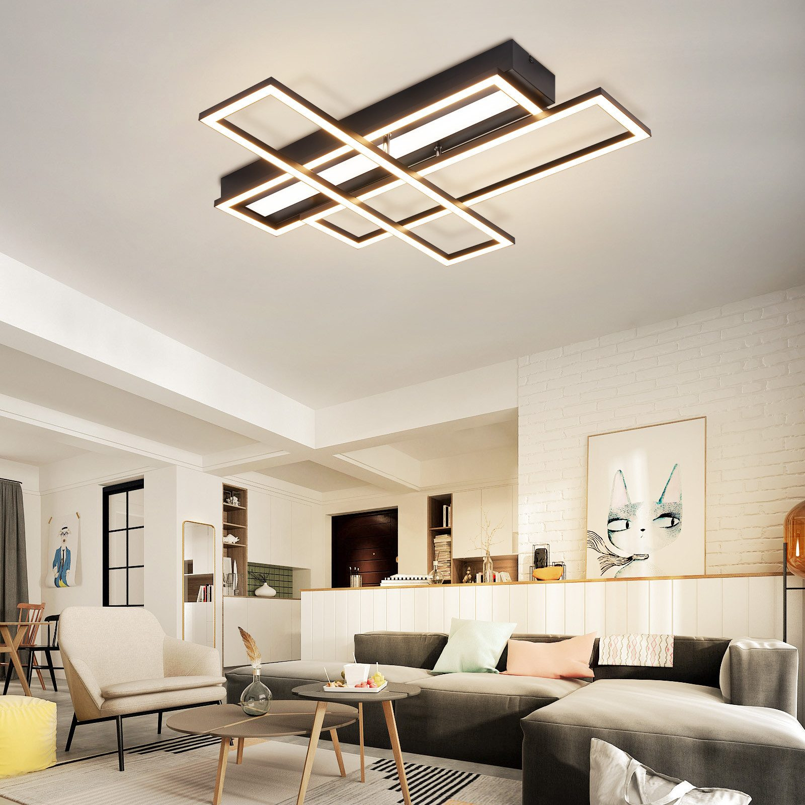 Soggiorno moderno con una lampada da soffitto geometrica, divani grigi e pareti dai colori chiari.