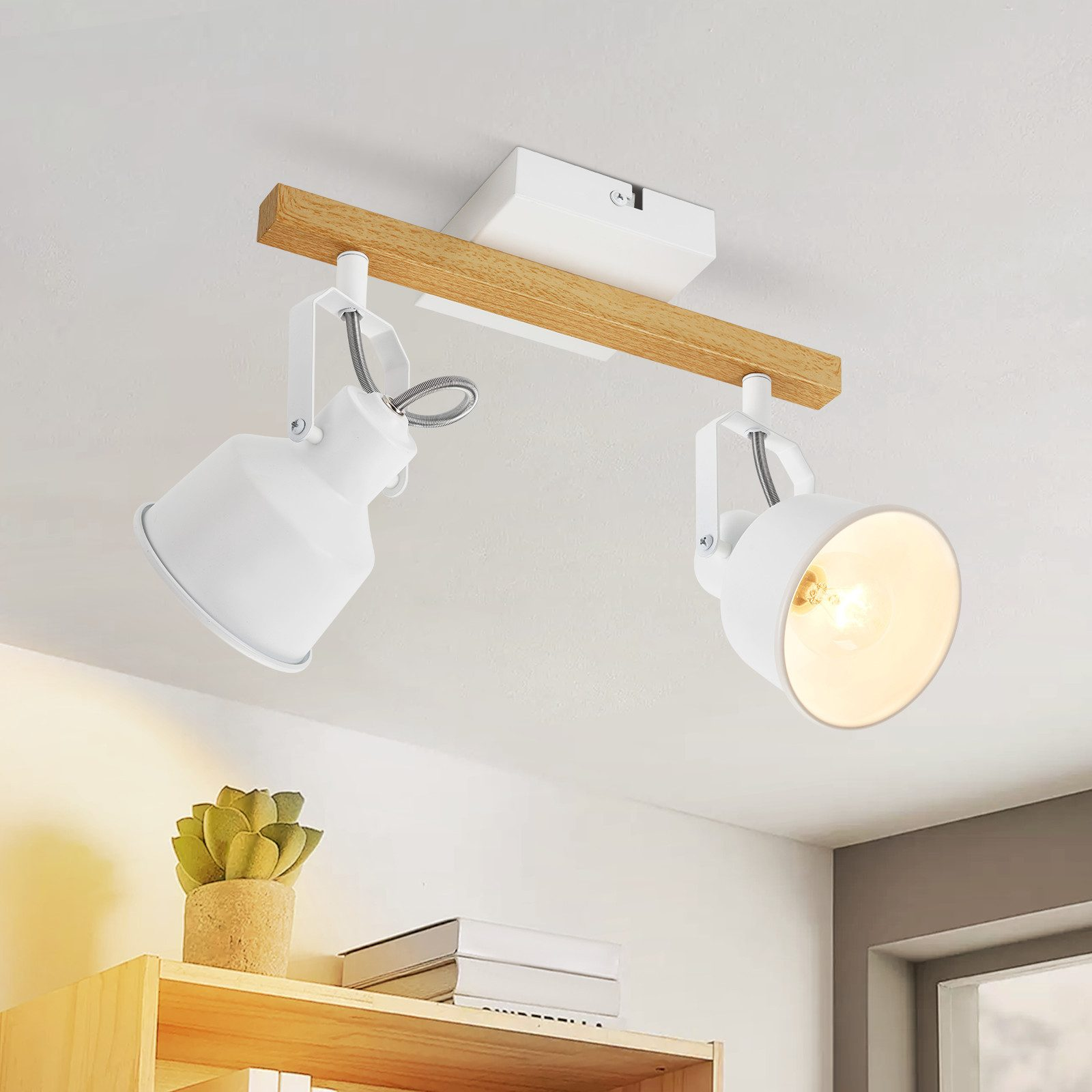 Due faretti bianchi su una trave di legno, montati a soffitto.
