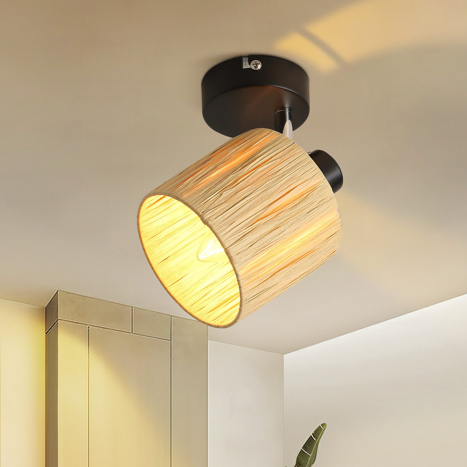 Una lampada da soffitto con paralume intrecciato emette una luce calda in un interno moderno.