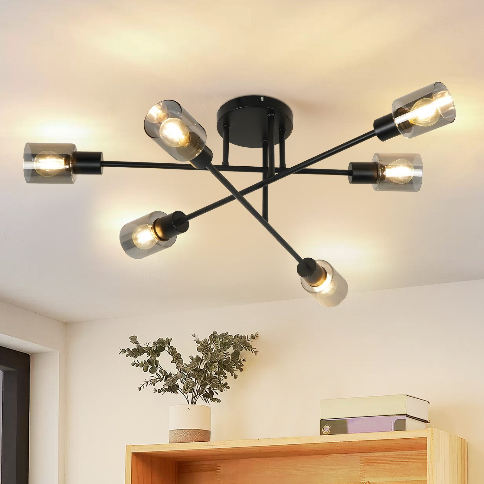 Lampada da soffitto con sei lampadine. Bracci neri si estendono da una base centrale nera.
