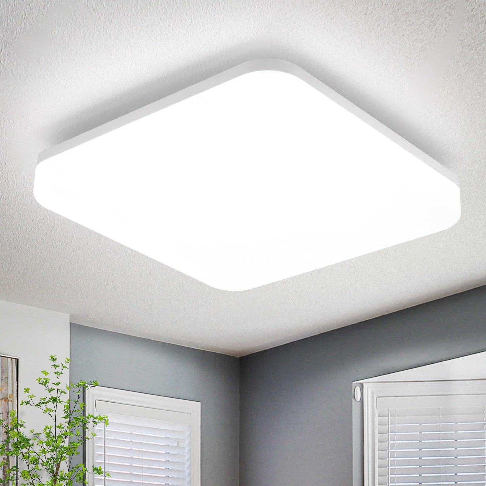 Una lampada da soffitto quadrata e bianca. La luce è intensa contro un soffitto bianco. La stanza è bianca.