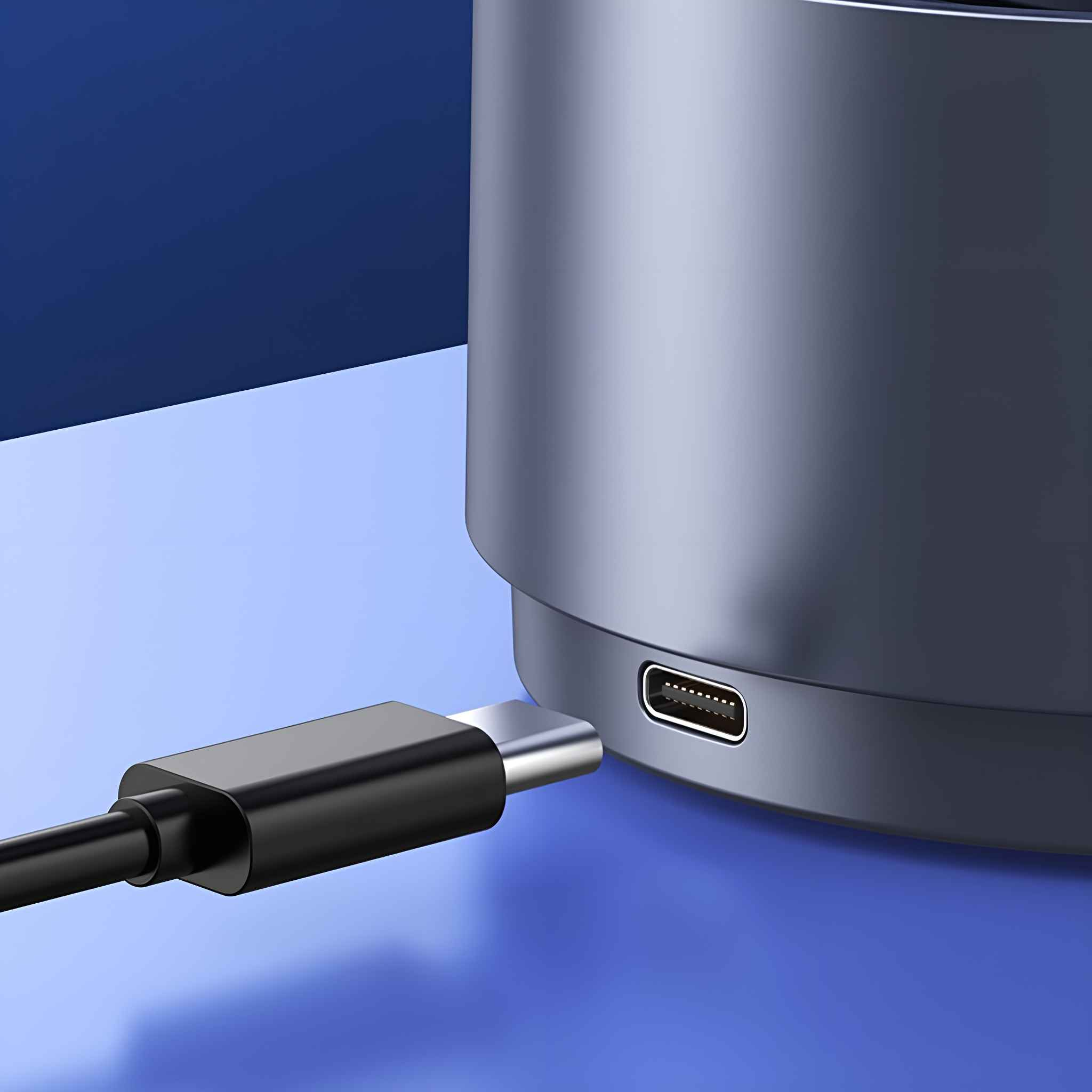 Ein USB-C-Kabel wird zum Aufladen eines tragbaren Ventilators vor einem blauen Hintergrund eingesteckt.